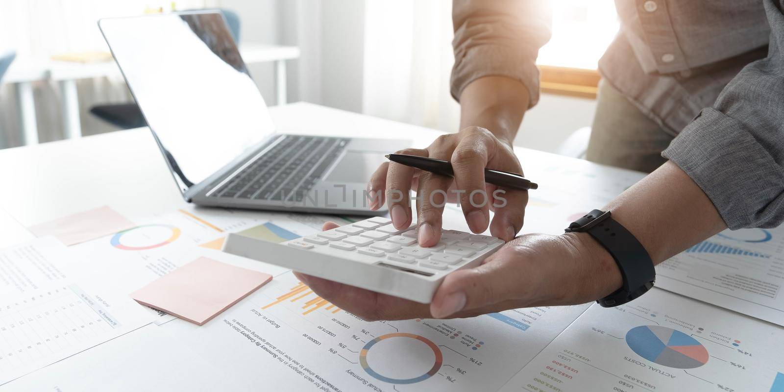 Close up businessman hand using calculator and working with laptop calculate about finance accounting at coffeeshop outdor.finance accounting concept.