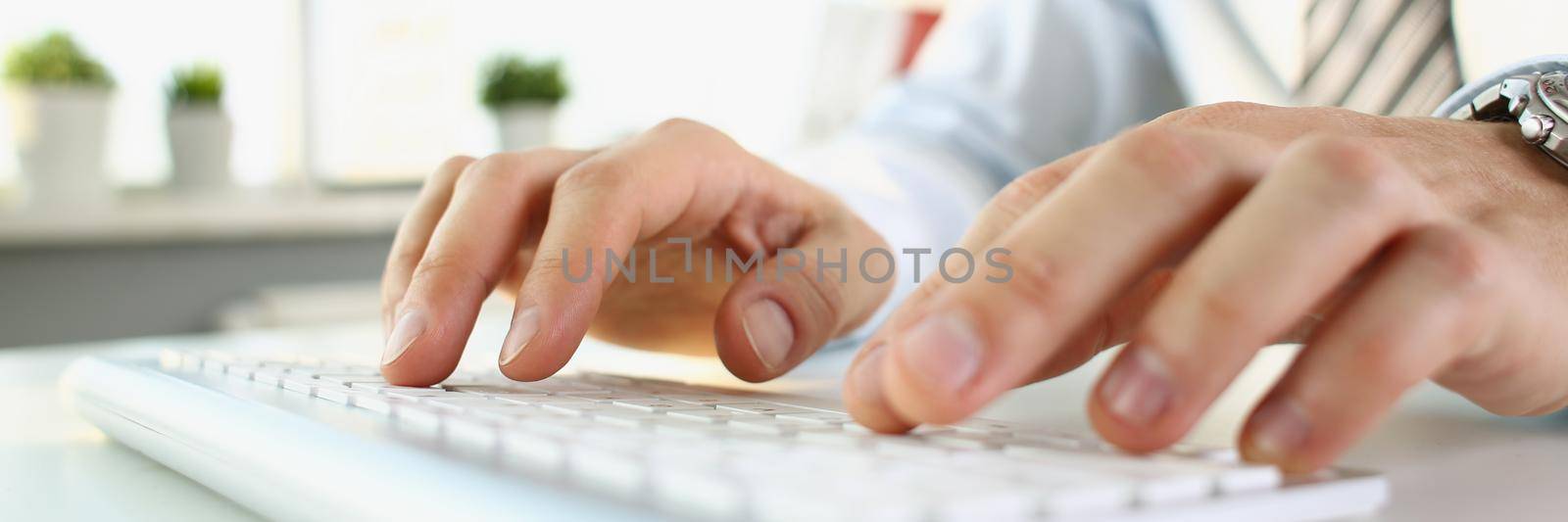 A man is typing on the keyboard, hands close-up, blurry. Office worker workplace, professional blind printing