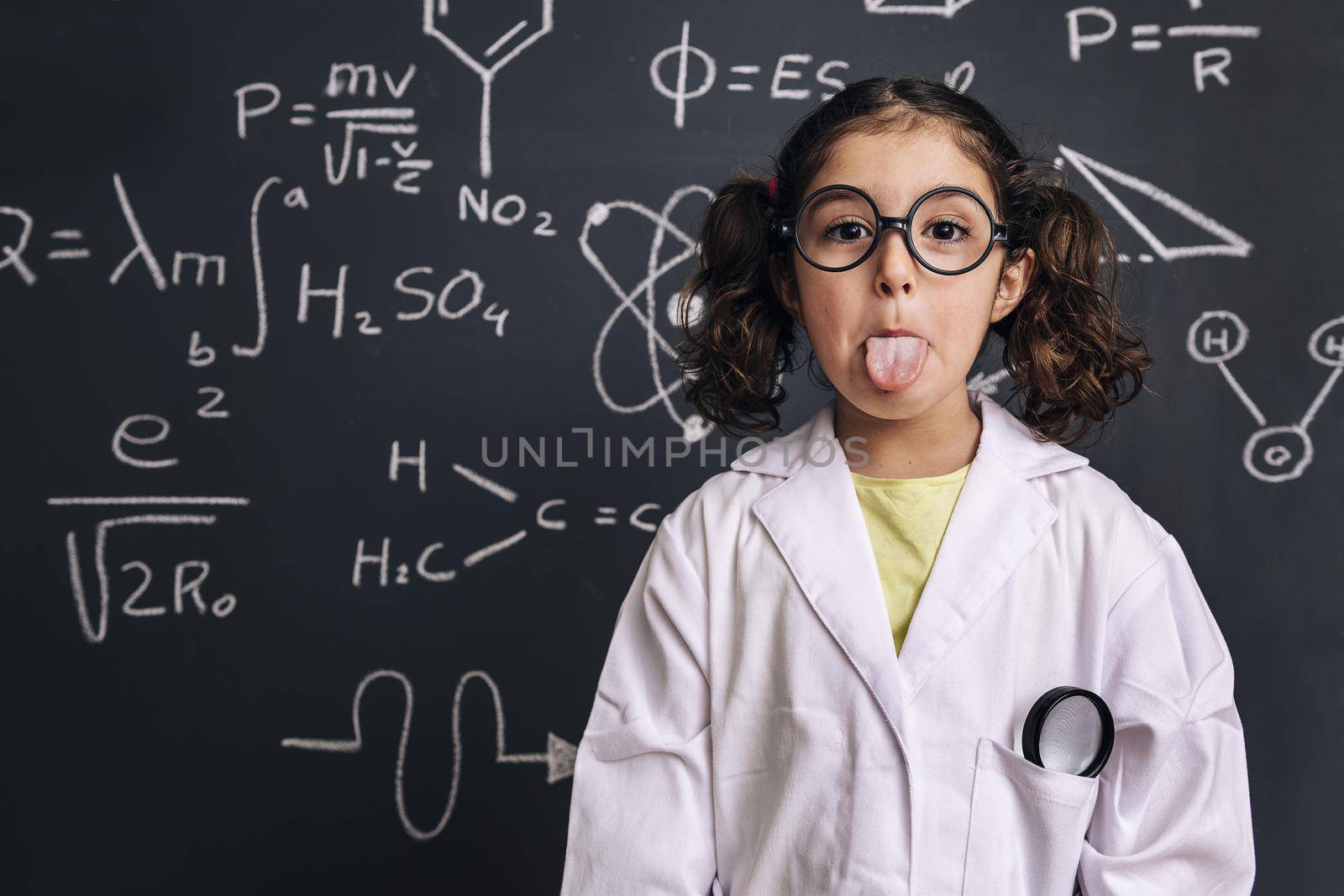 fun little girl scientist sticking her tongue out