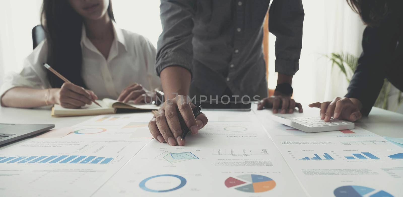 Business People Meeting using laptop computer, calculator,notebook,stock market chart paper for analysis Plans to improve quality next month. Conference Discussion Corporate Concept.