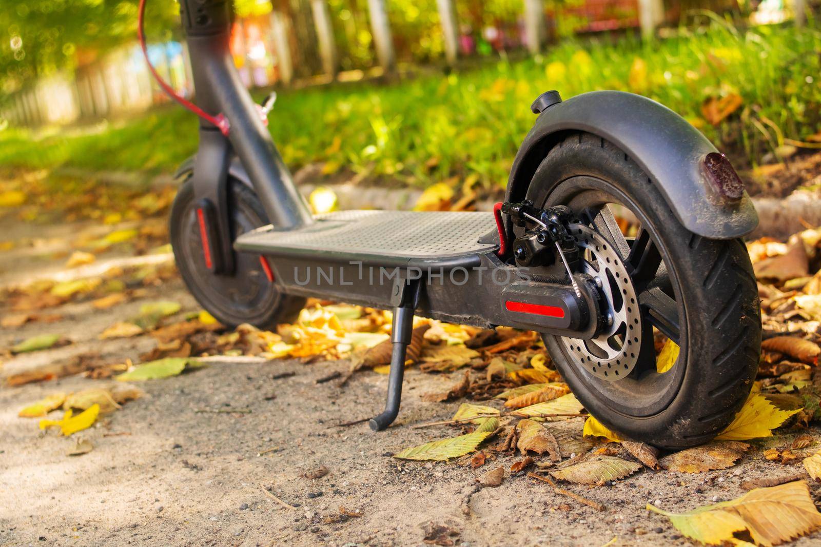 Electric scooter in yellow autumn leaves close up