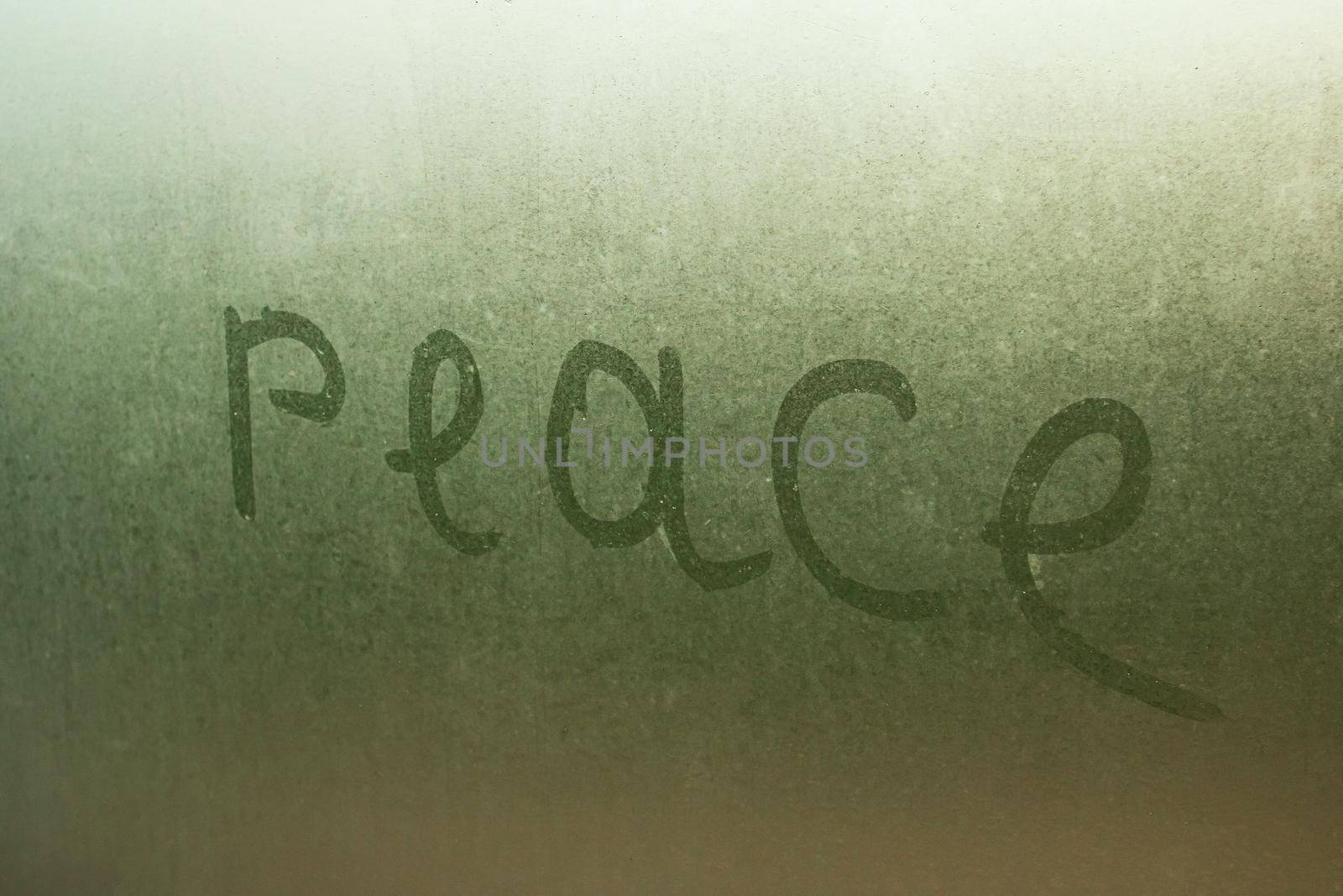 Inscription peace on a wet glass close up