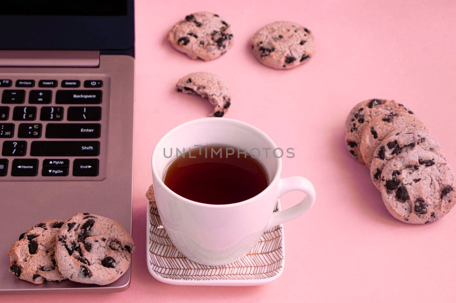 home office laptop chocolate chip cookies and tea cup. High quality photo