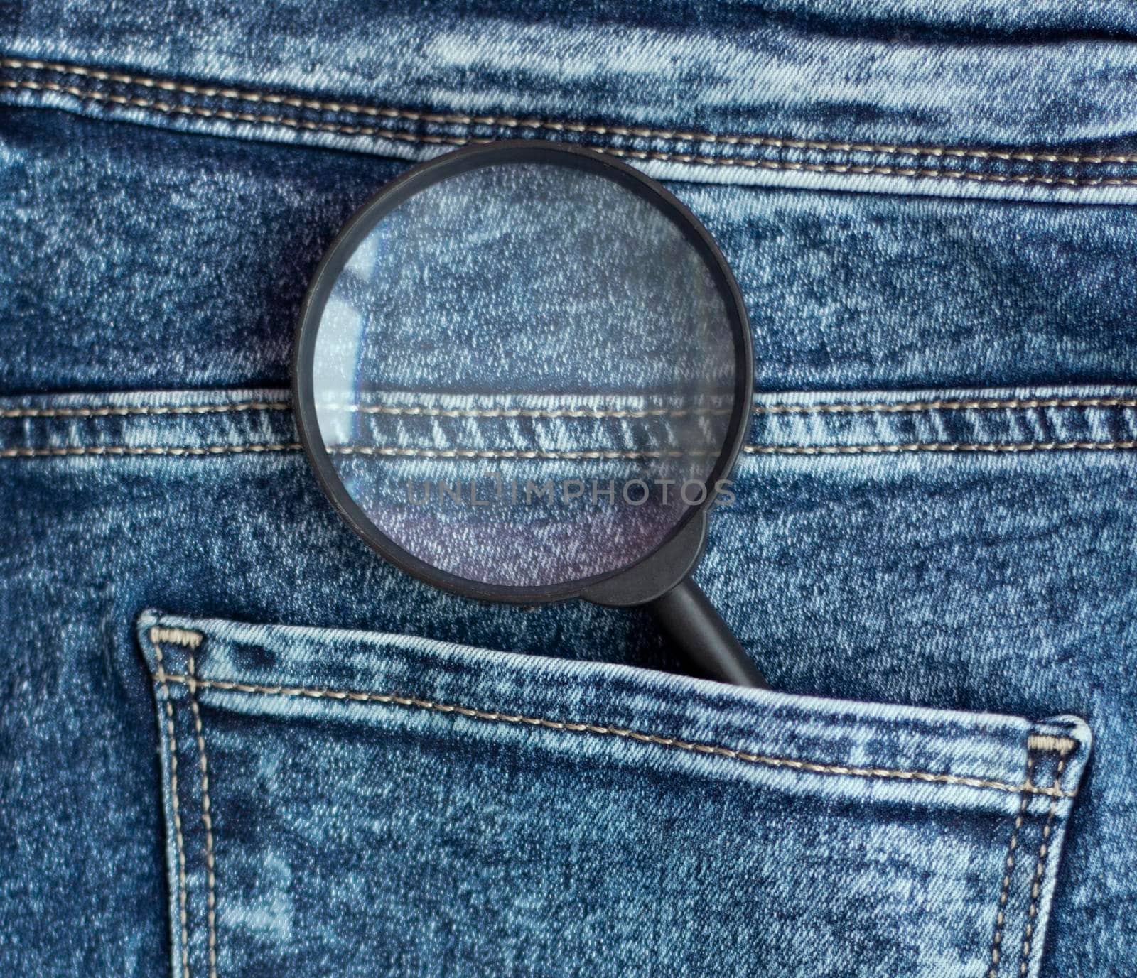 magnifier in the back pocket of jeans. Constant search concept. Back pocket. Stitching on jeans. High quality photo