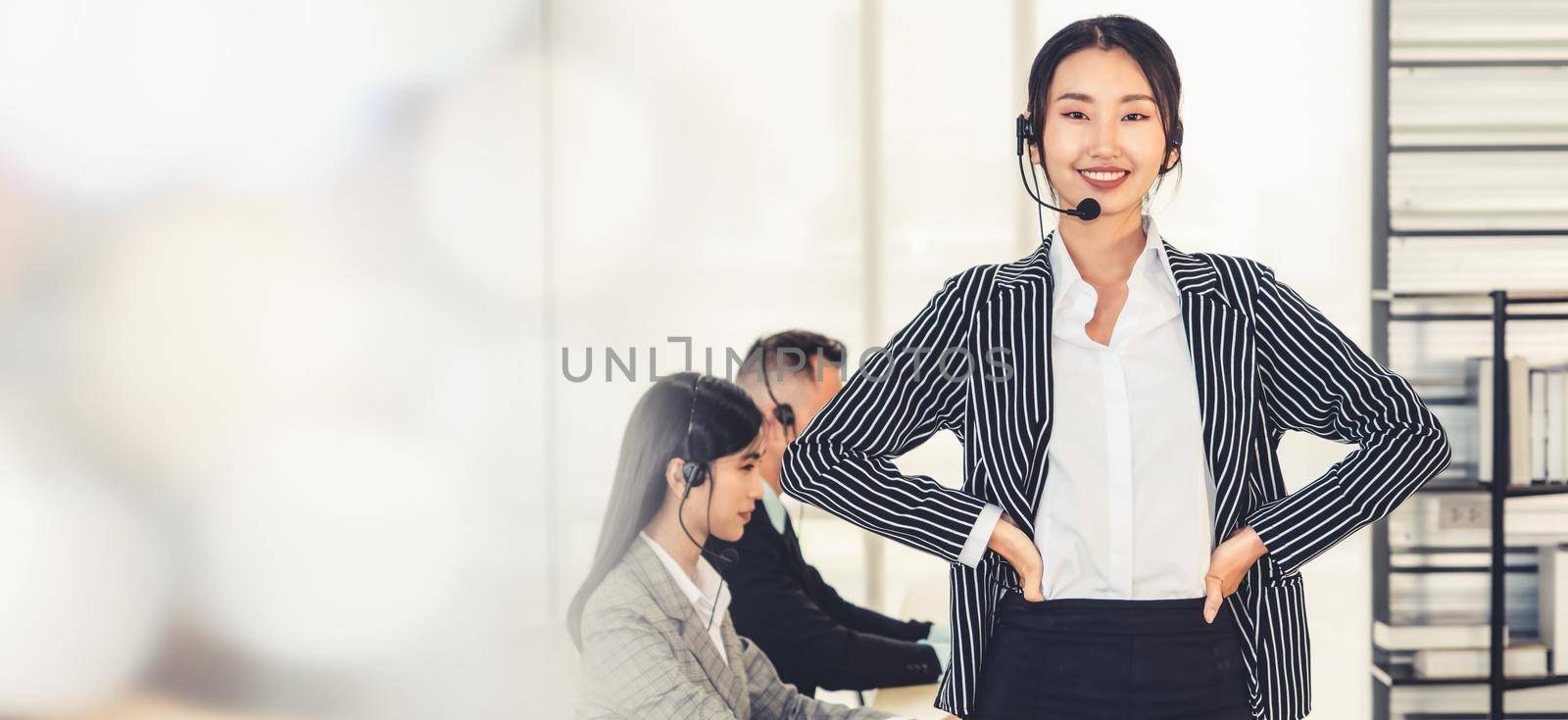 Business people wearing headset working in office to support remote customer or colleague. Call center, telemarketing, customer support agent provide service in broaden view .