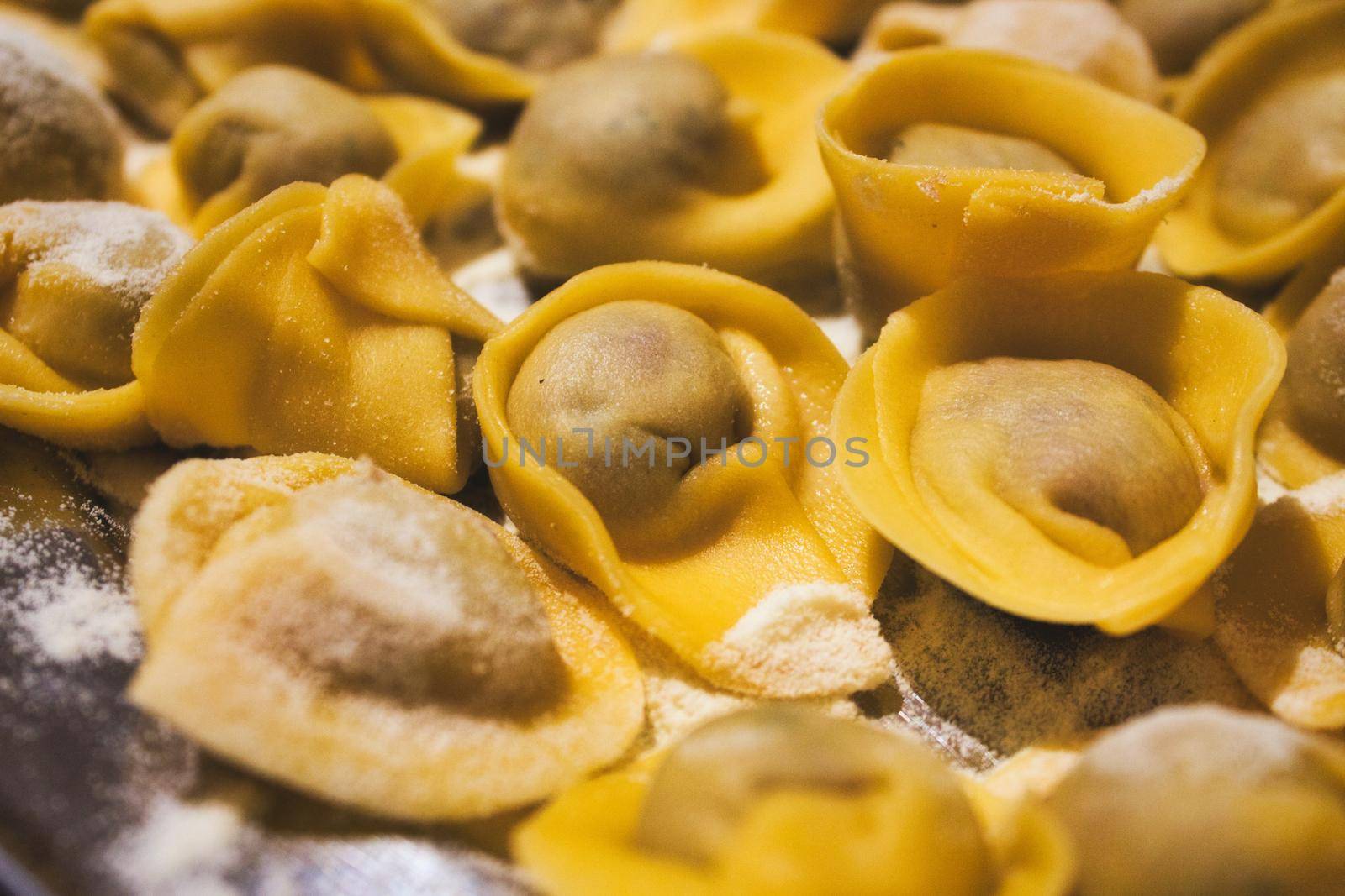 Close-up of fresh pasta tortellini covered in grated parmesan cheese