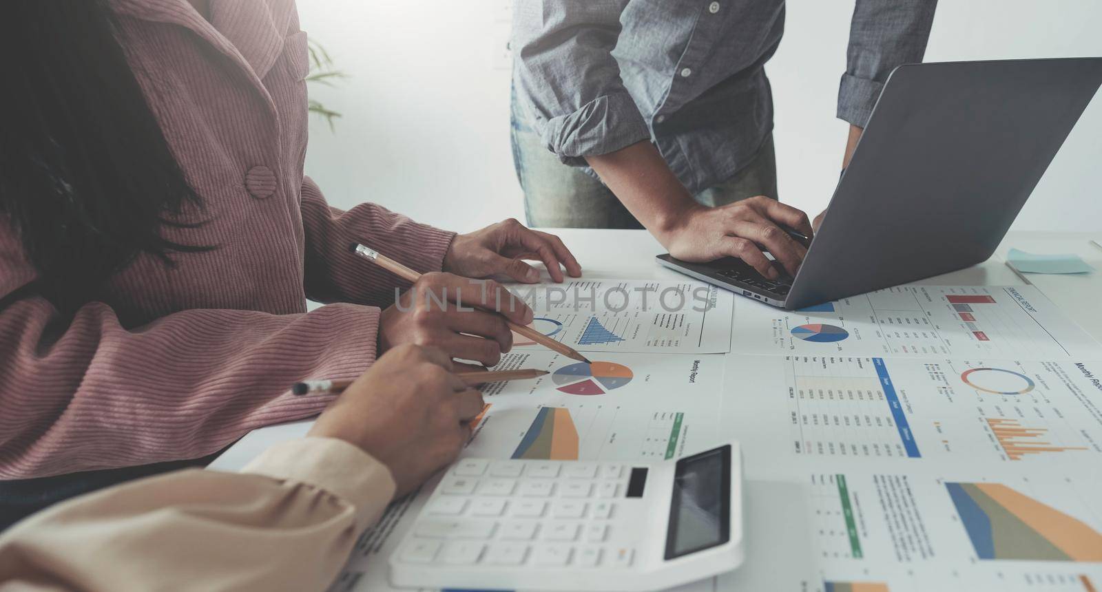 Business People Meeting using laptop computer, calculator,notebook,stock market chart paper for analysis Plans to improve quality next month. Conference Discussion Corporate Concept.