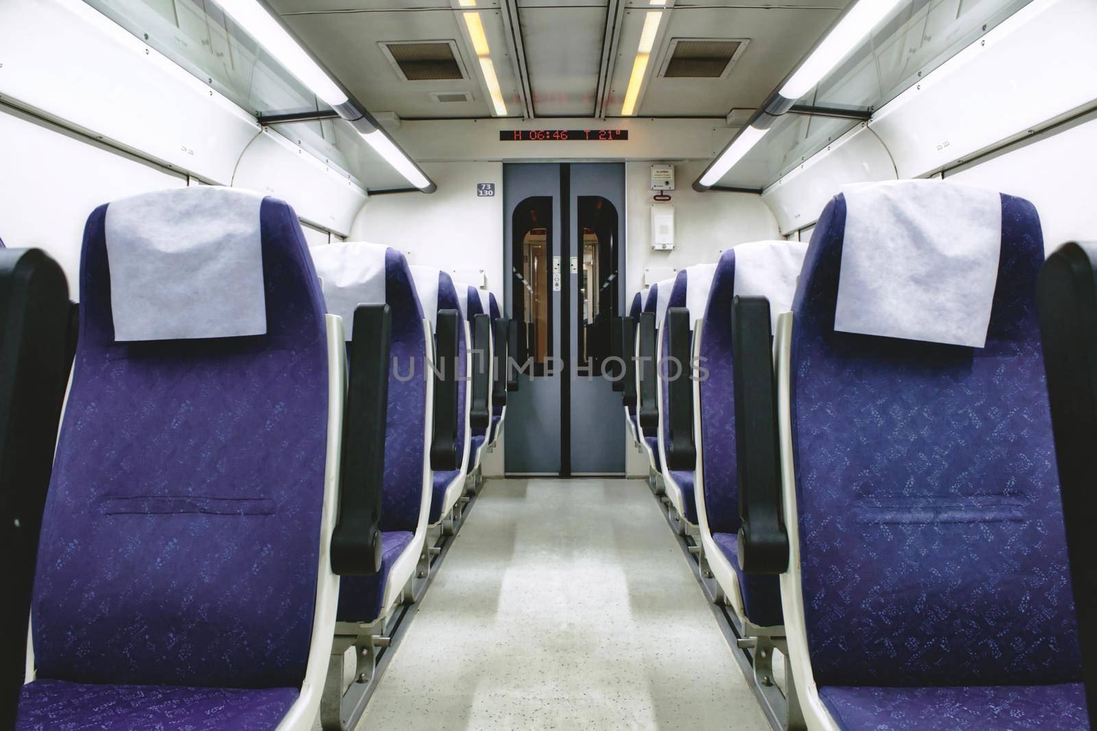 Interior of train carriage between rows of empty chairs by tennesseewitney