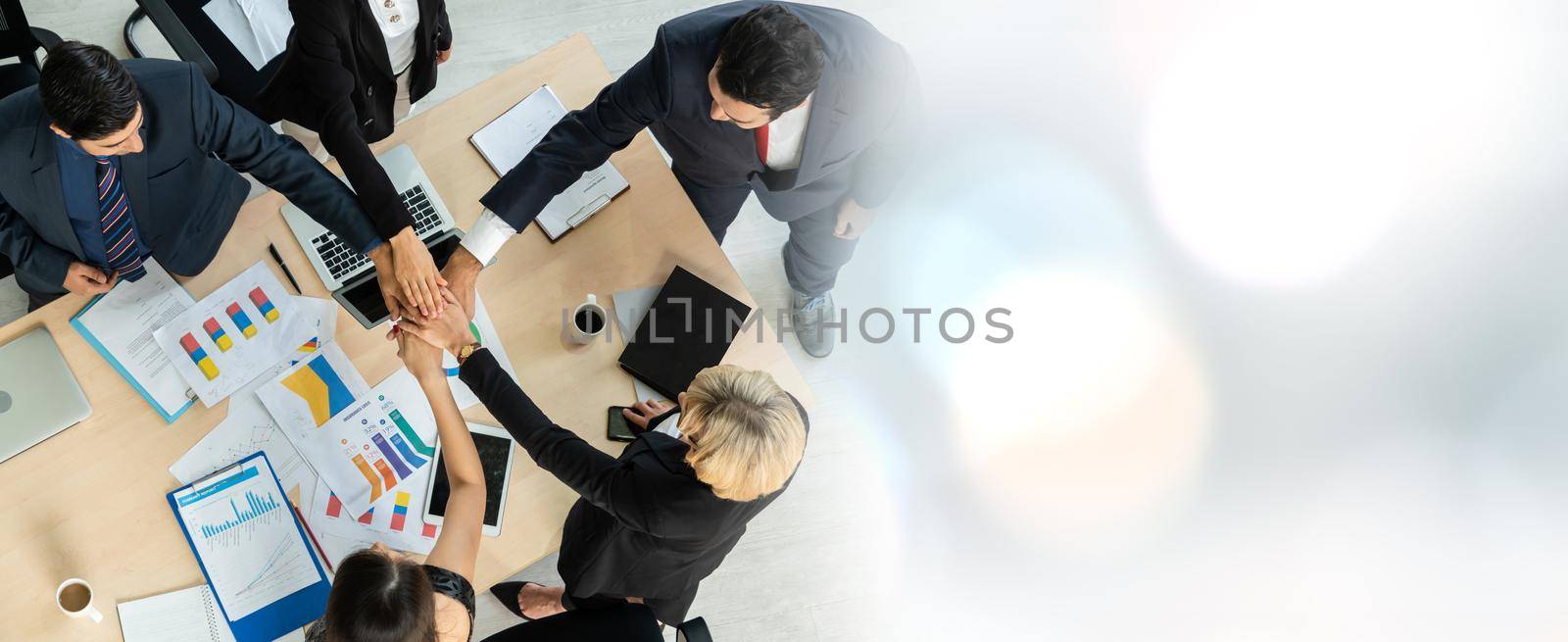 Happy business people celebrate teamwork success in widen view together with joy at office table shot from top view . Young businessman and businesswoman workers express cheerful victory .