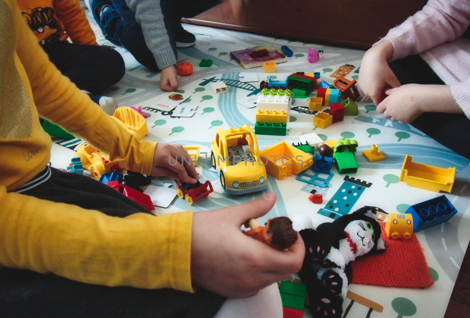 Kids playing with building blocks toys on a play mat by tennesseewitney