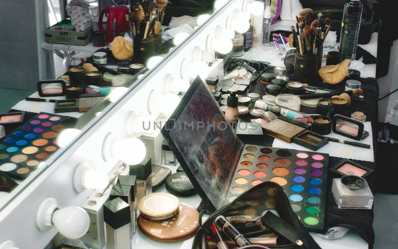 Rabat / Malta - December 8 2019: Makeup products, accessories and tools on a salon table in front of a light mirror