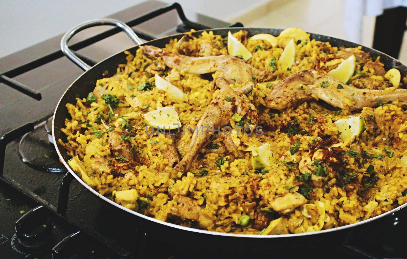 A big shallow pan dish containing paella with rice and meat by tennesseewitney