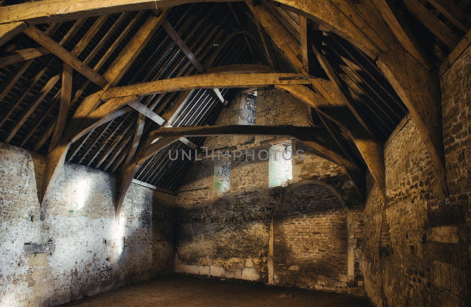 Interior of an old medieval barn in a typical village in England by tennesseewitney