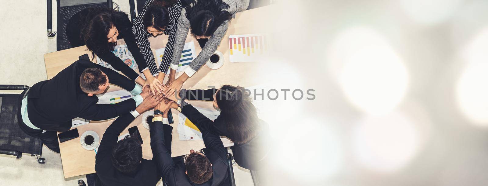 Happy business people celebrate teamwork success together with joy at office table shot from top view . Young businessman and businesswoman workers express cheerful victory in broaden view .