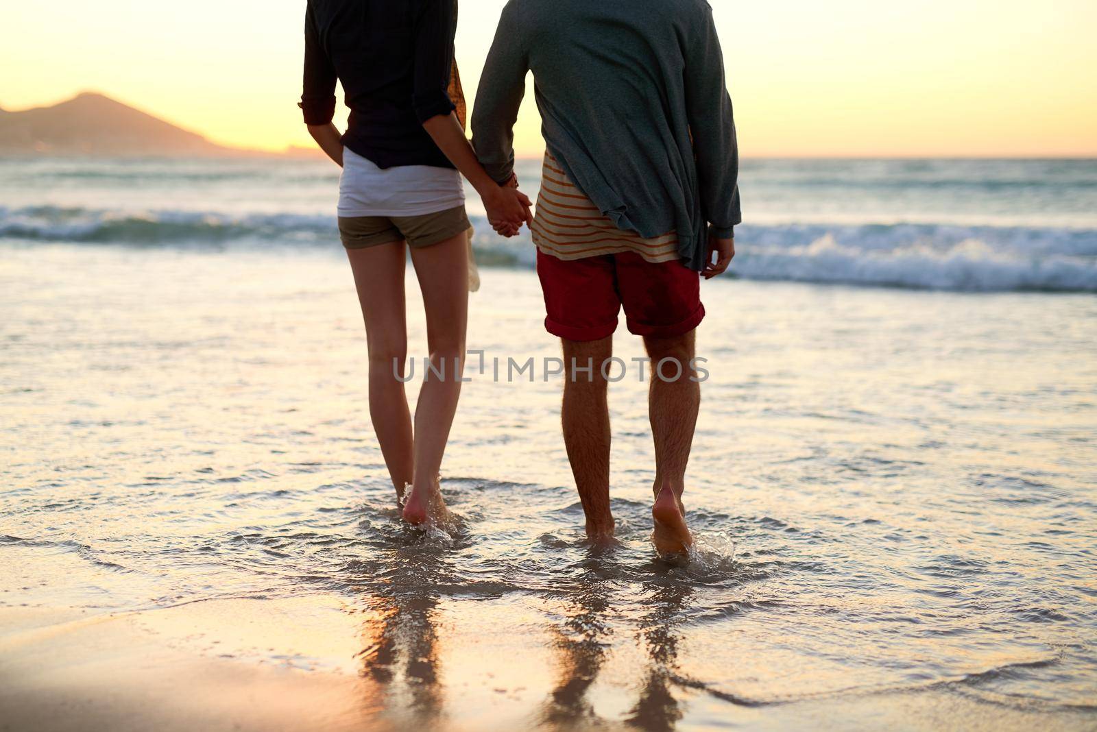 Rearview shot of an unrecognizable couple taking a walk towards the beach.