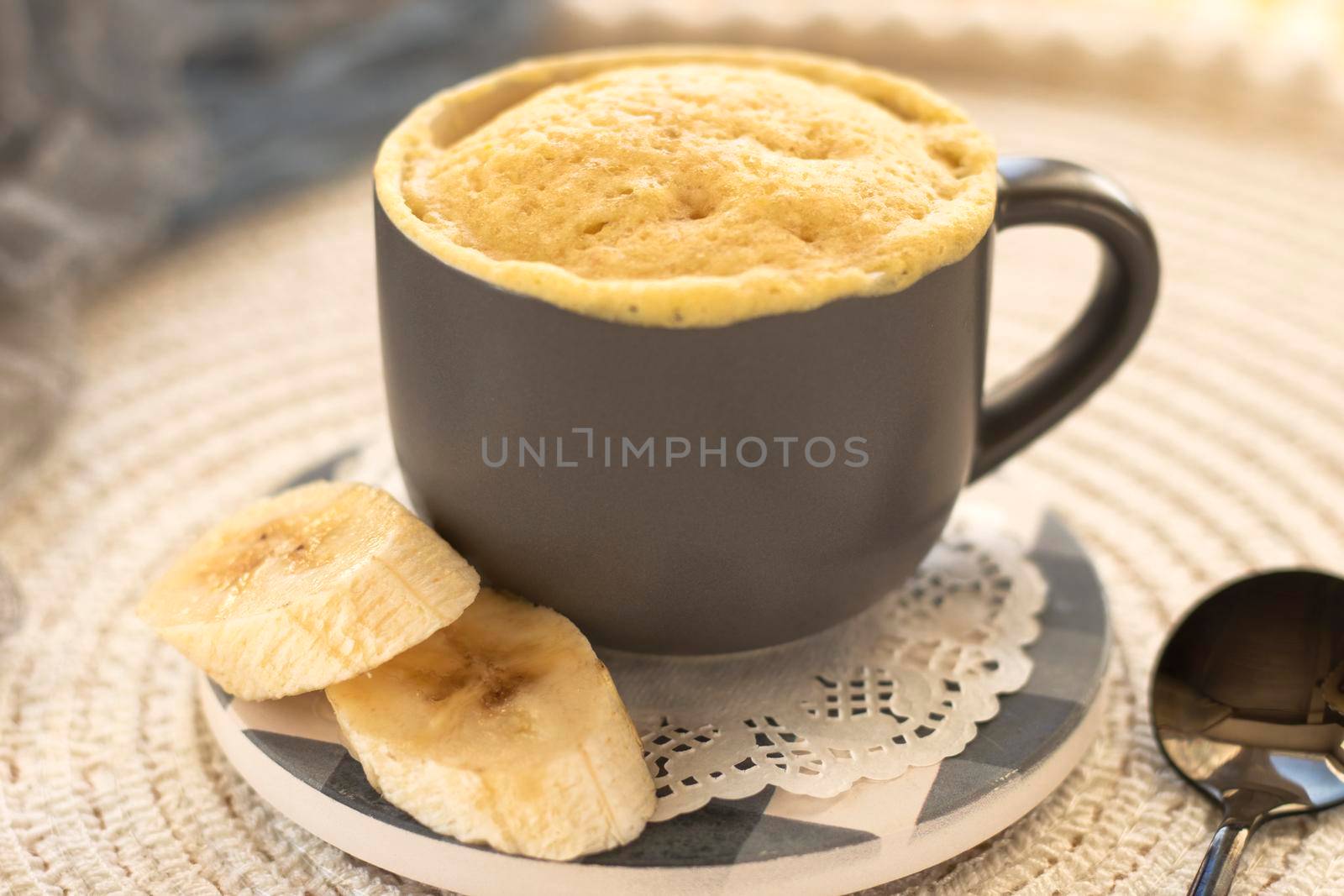 selective focus. homemade Portioned Banana bread mugcake in small mugs. Easy sweet baking in the microwave idea, With fresh bananas, nuts. Muffin with banana slices cooked in a mug. copy space.