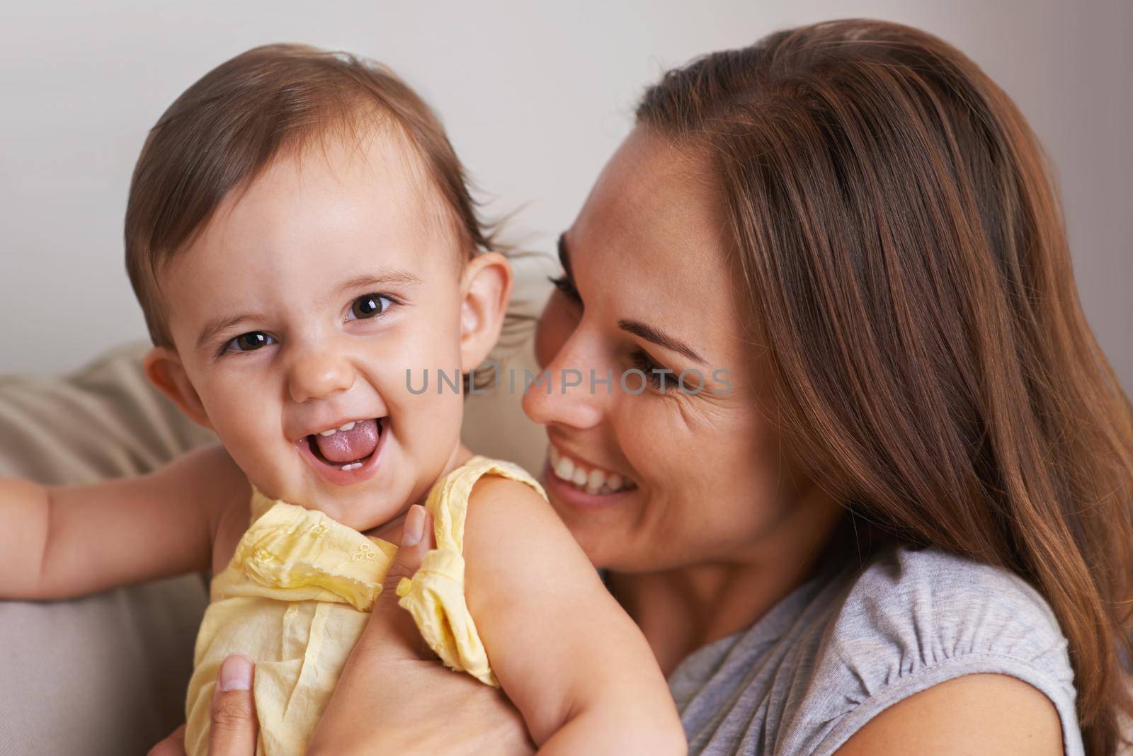 Closeup portrait of a mother and baby daughter laughing.