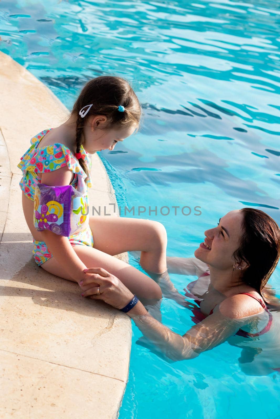 mother with baby in swimming pool. young woman with her daughter by Suietska