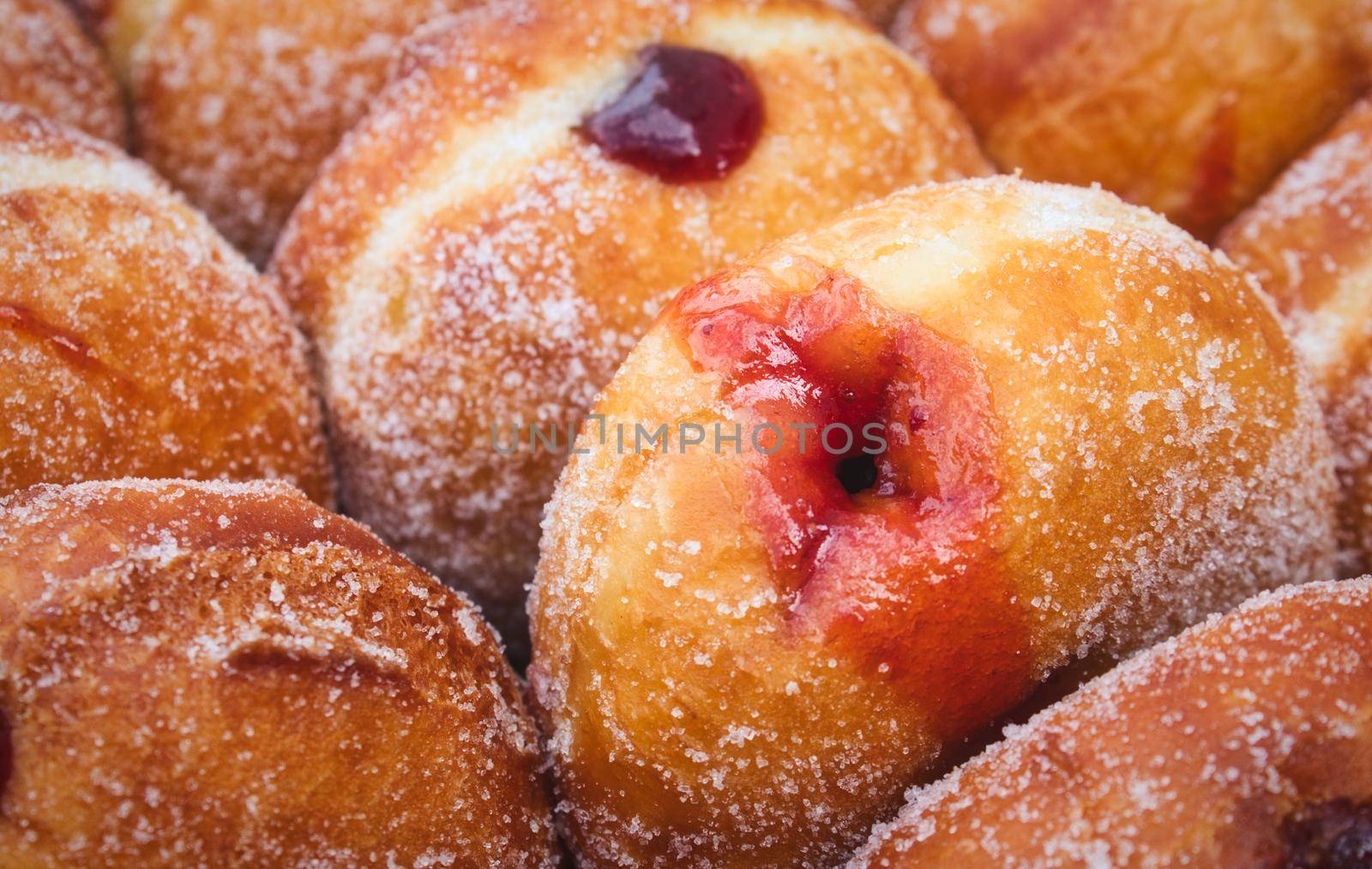 Close-up of a heap of jam-filled sugar-coated doughnuts by tennesseewitney