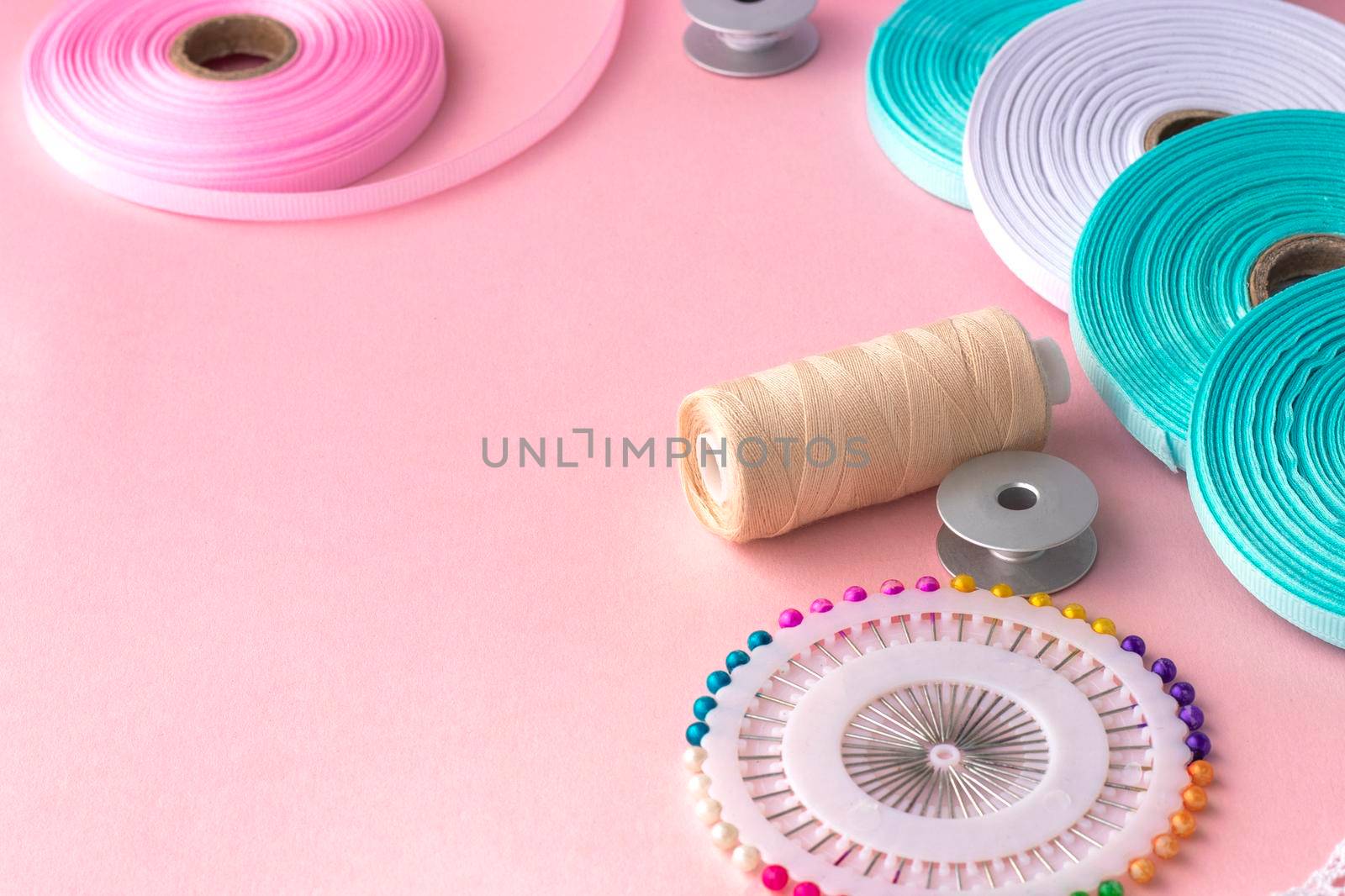 Handmade and sewing background. sewing accessories for needlework on pink background. Spool of thread, multicolored tapes, sewing supplies. Handmade set with copy space. High quality photo