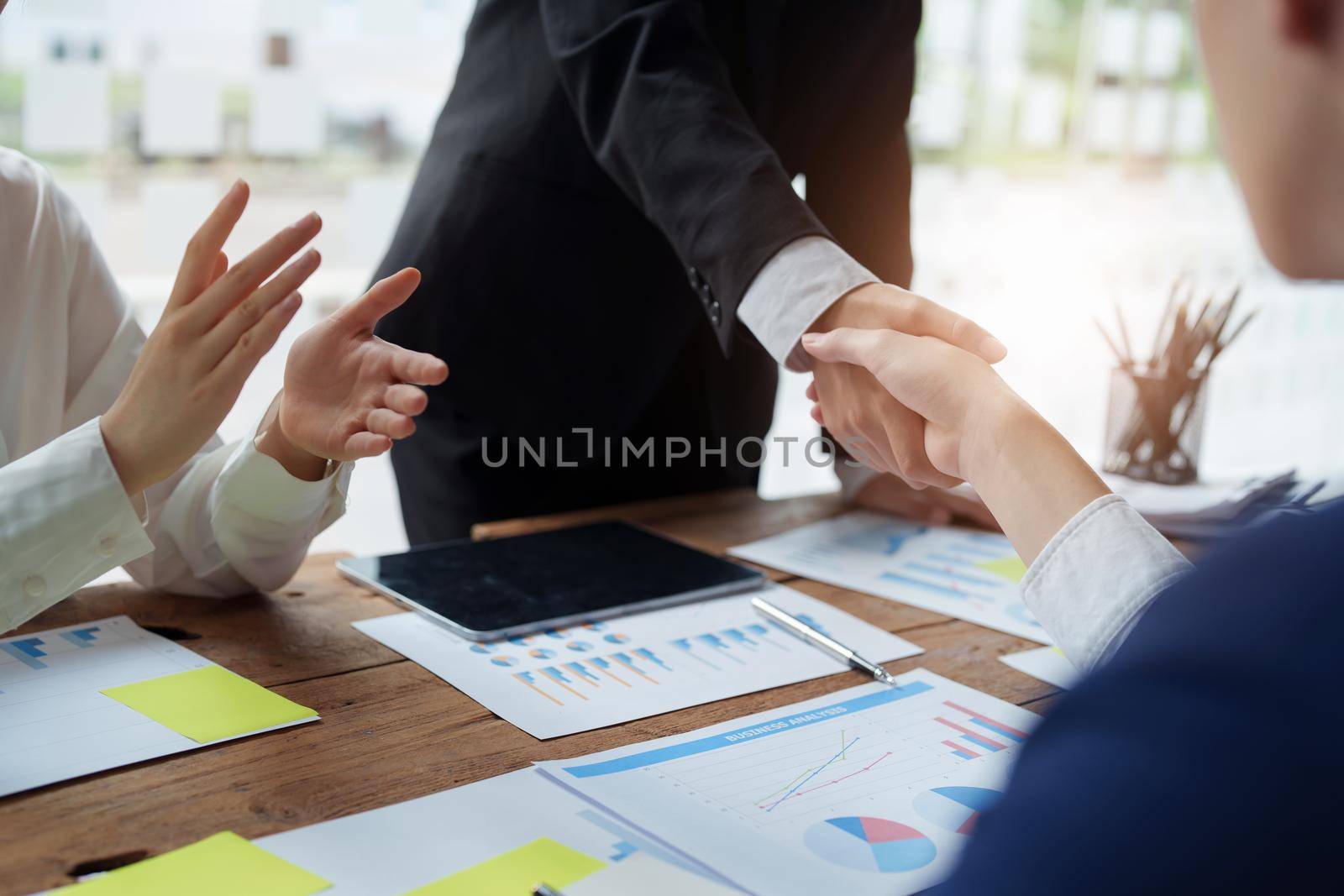 Asian entrepreneurs handshakes to congratulate the agreement between the two companies to enhance investment and financial strength. deal concept.