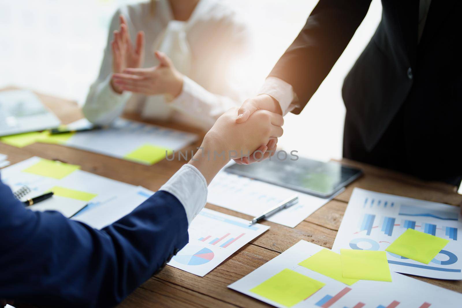 Asian entrepreneurs handshakes to congratulate the agreement between the two companies to enhance investment and financial strength. deal concept by Manastrong