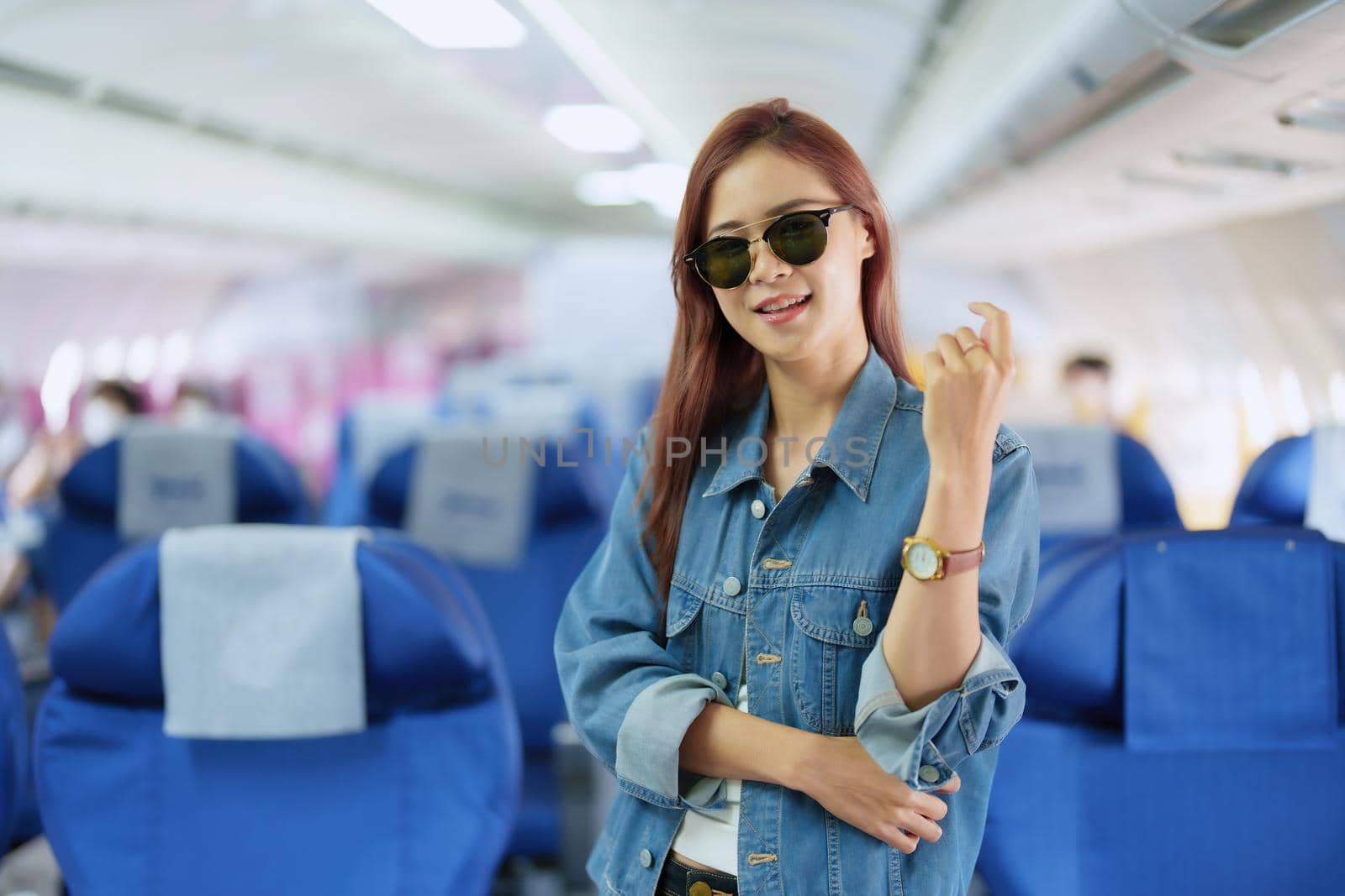 travel business Portrait of an Asian woman showing joy while waiting for a flight by Manastrong