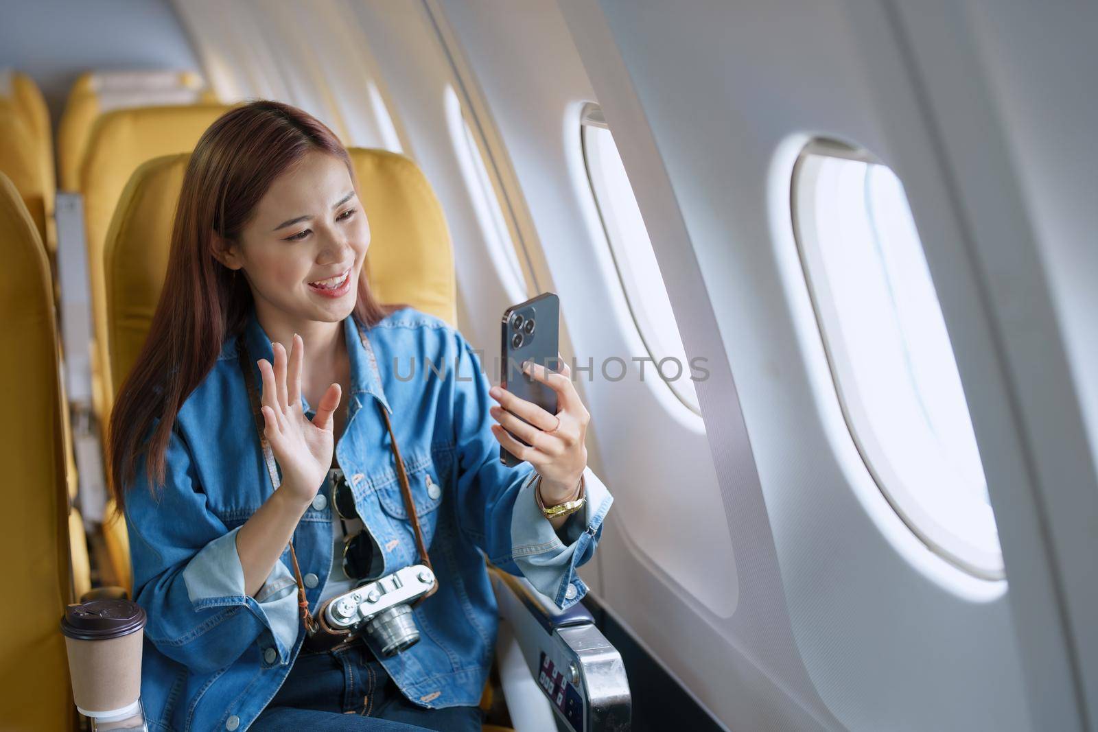 Travel, tourism business, portrait of a woman using her phone selfie on an airplane to post a profile picture of herself by Manastrong