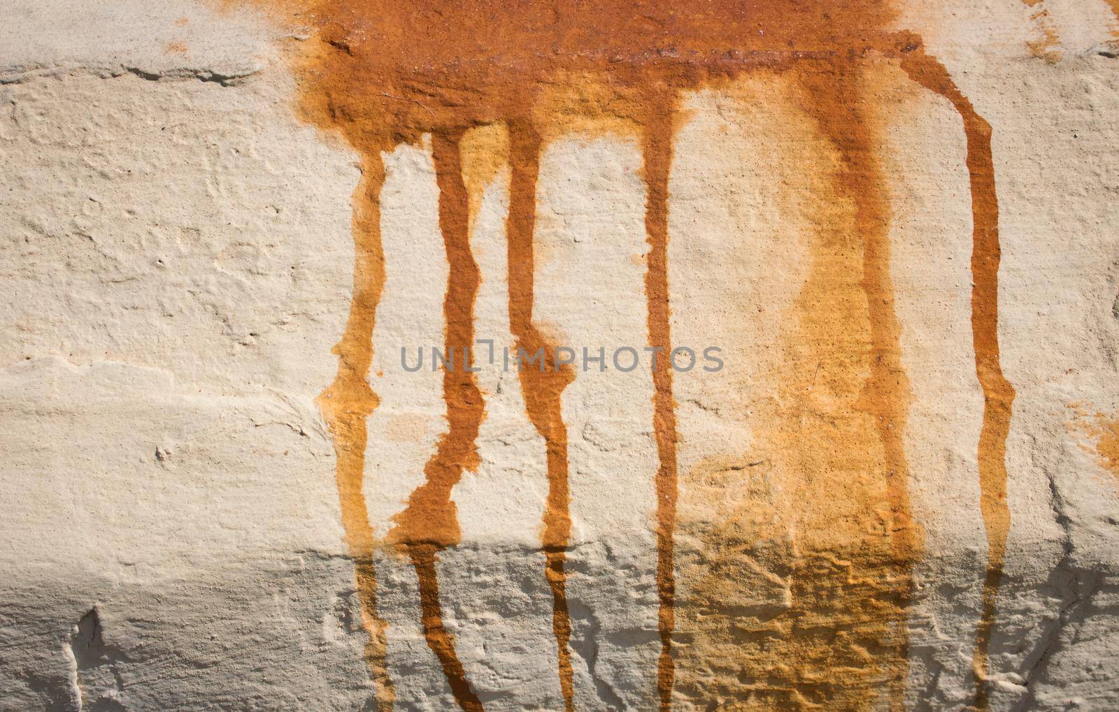 Grungy wall background with red rusty stain dripping down from rain corrosion by tennesseewitney