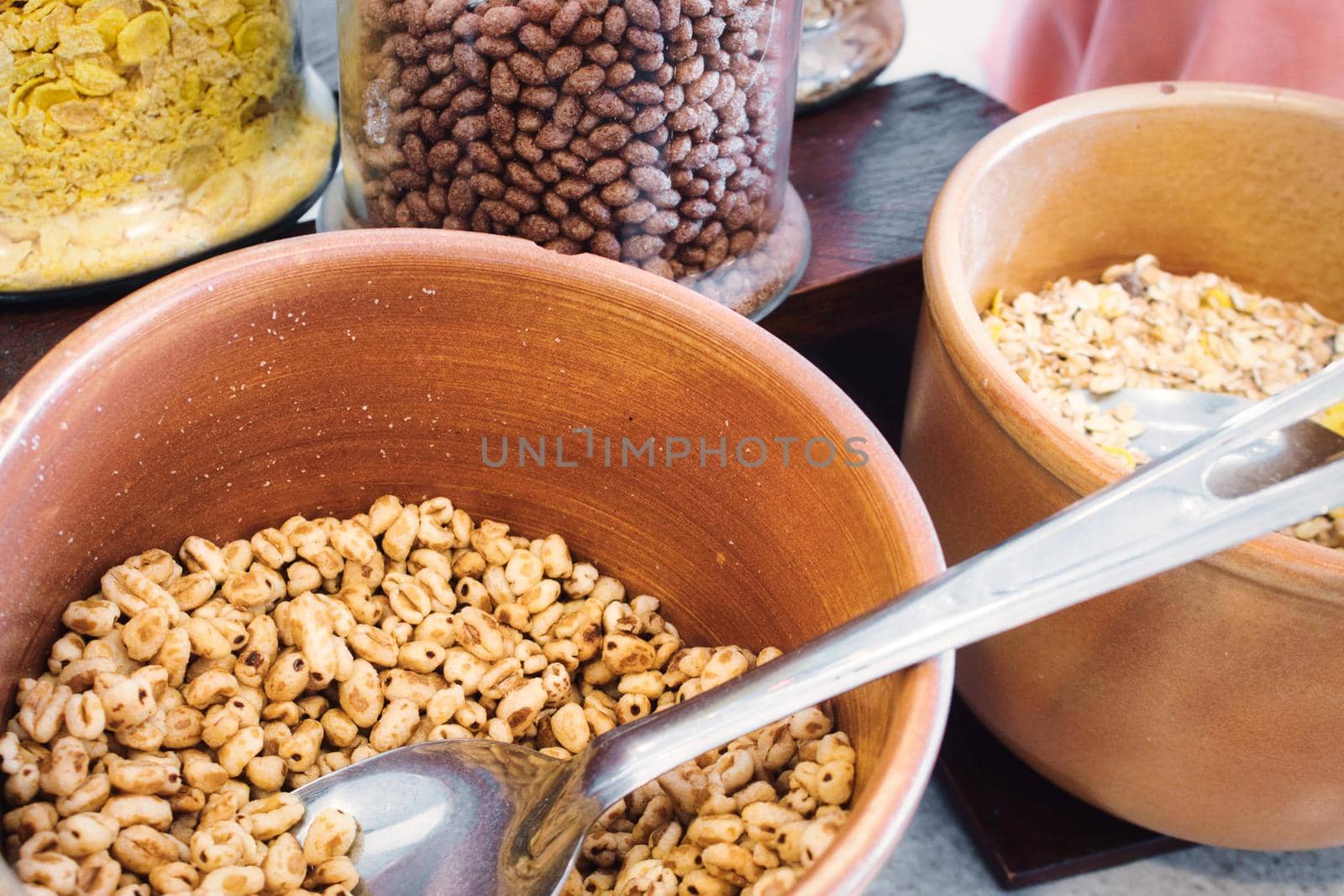 Ceramic bowls and glass jars with various cereals for breakfast