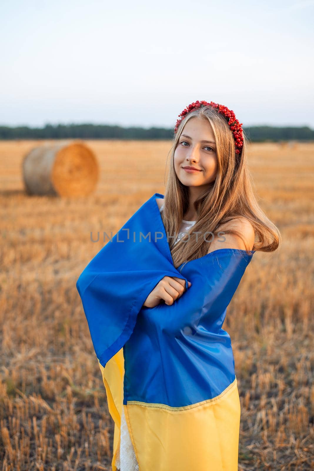 Patriotic girl in the field after the harvest