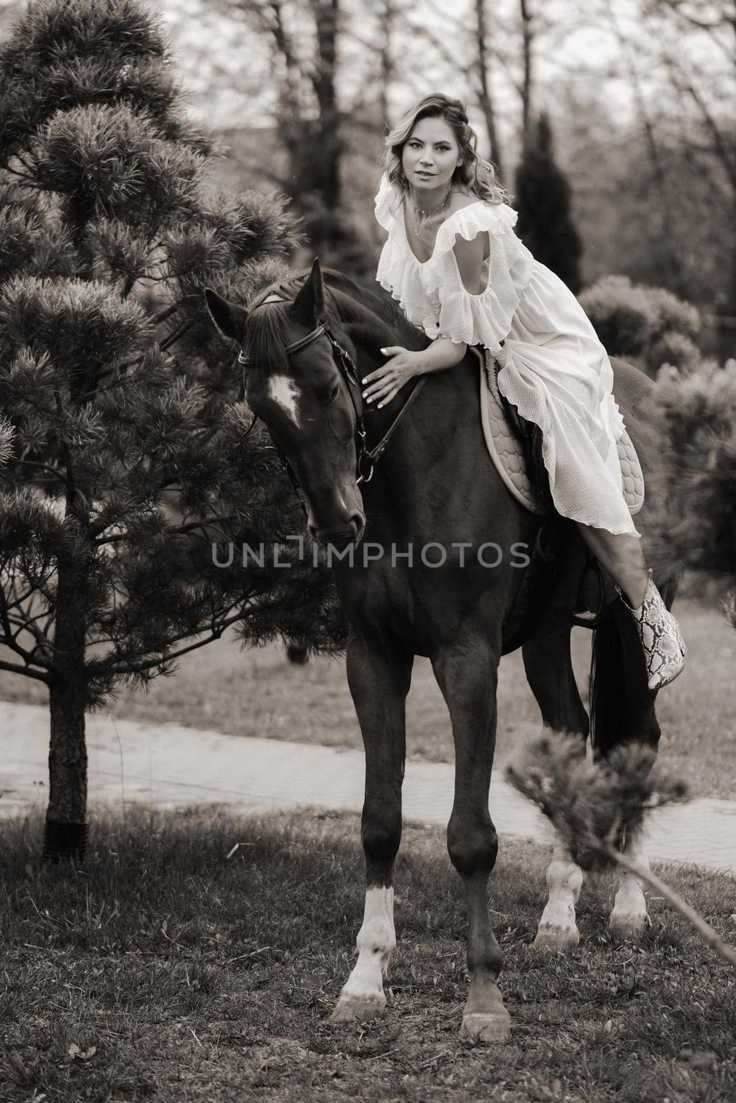 A woman in a white sundress riding a horse near a farm. black and white photo by Lobachad