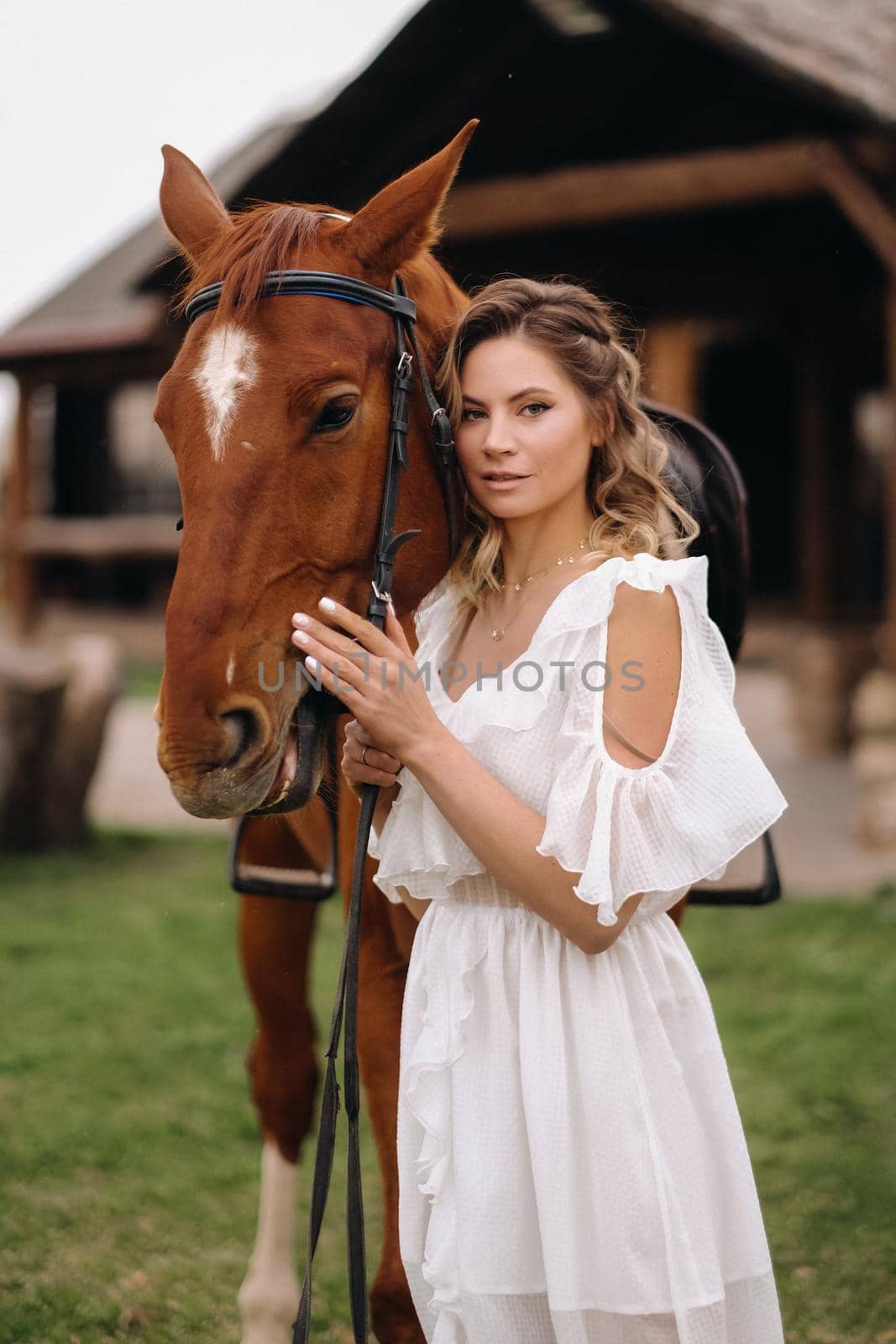 Beautiful girl in a white sundress next to a horse on an old ranch by Lobachad