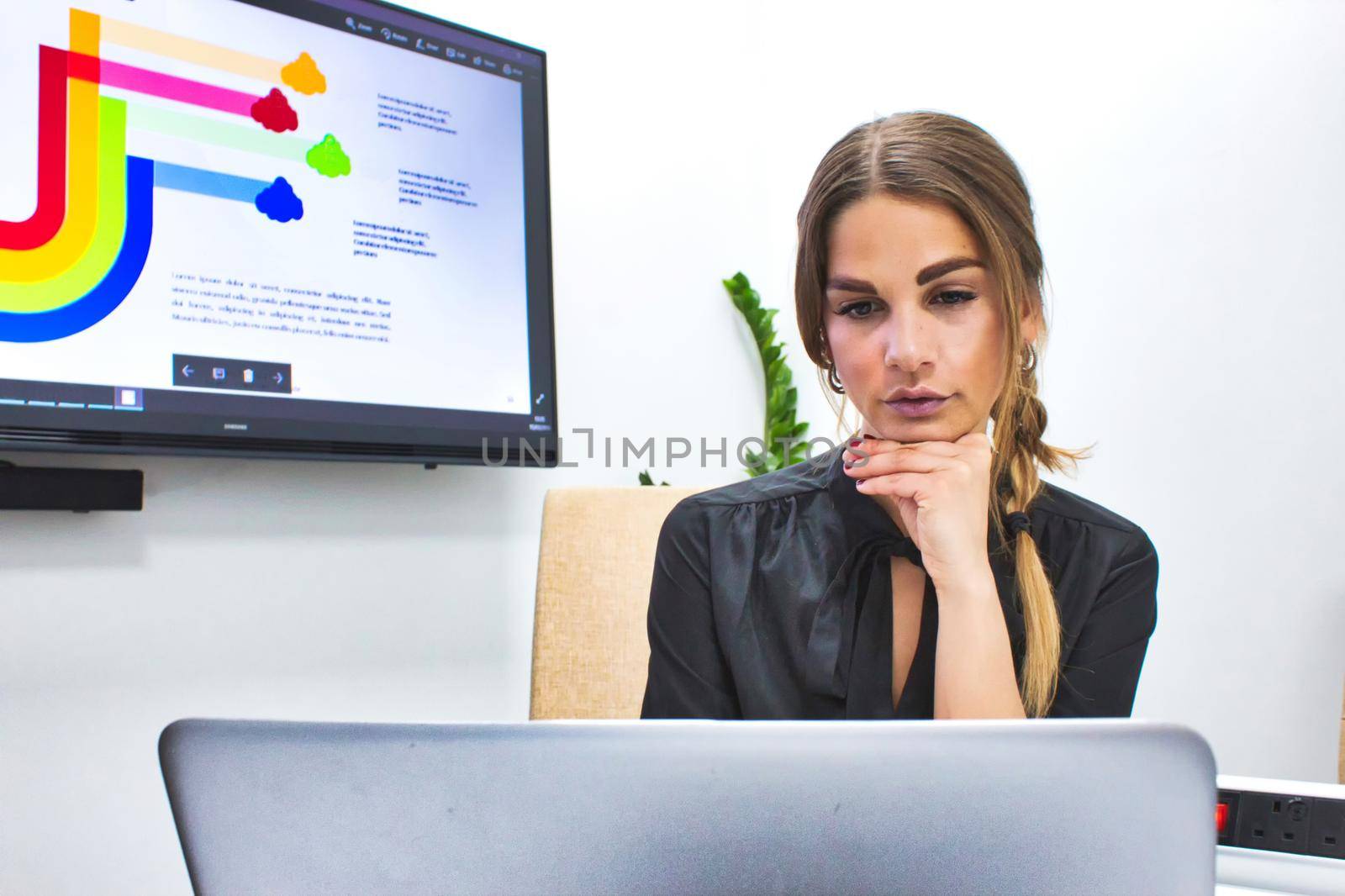 Businesswoman working on her laptop on a conference table in a meeting room at the office