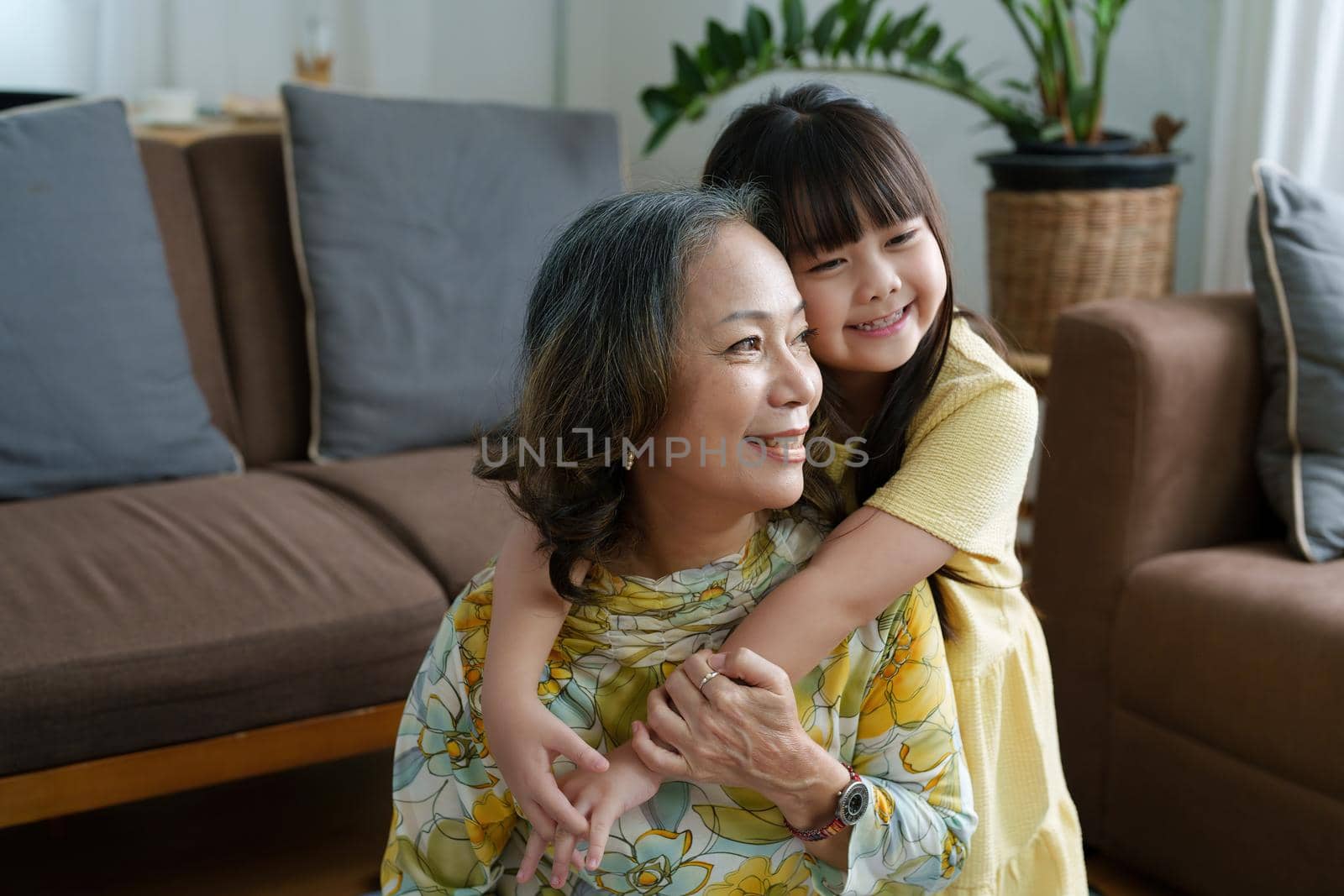 Asian portrait, grandma and granddaughter doing leisure activities and hugging to show their love and care for each other by Manastrong