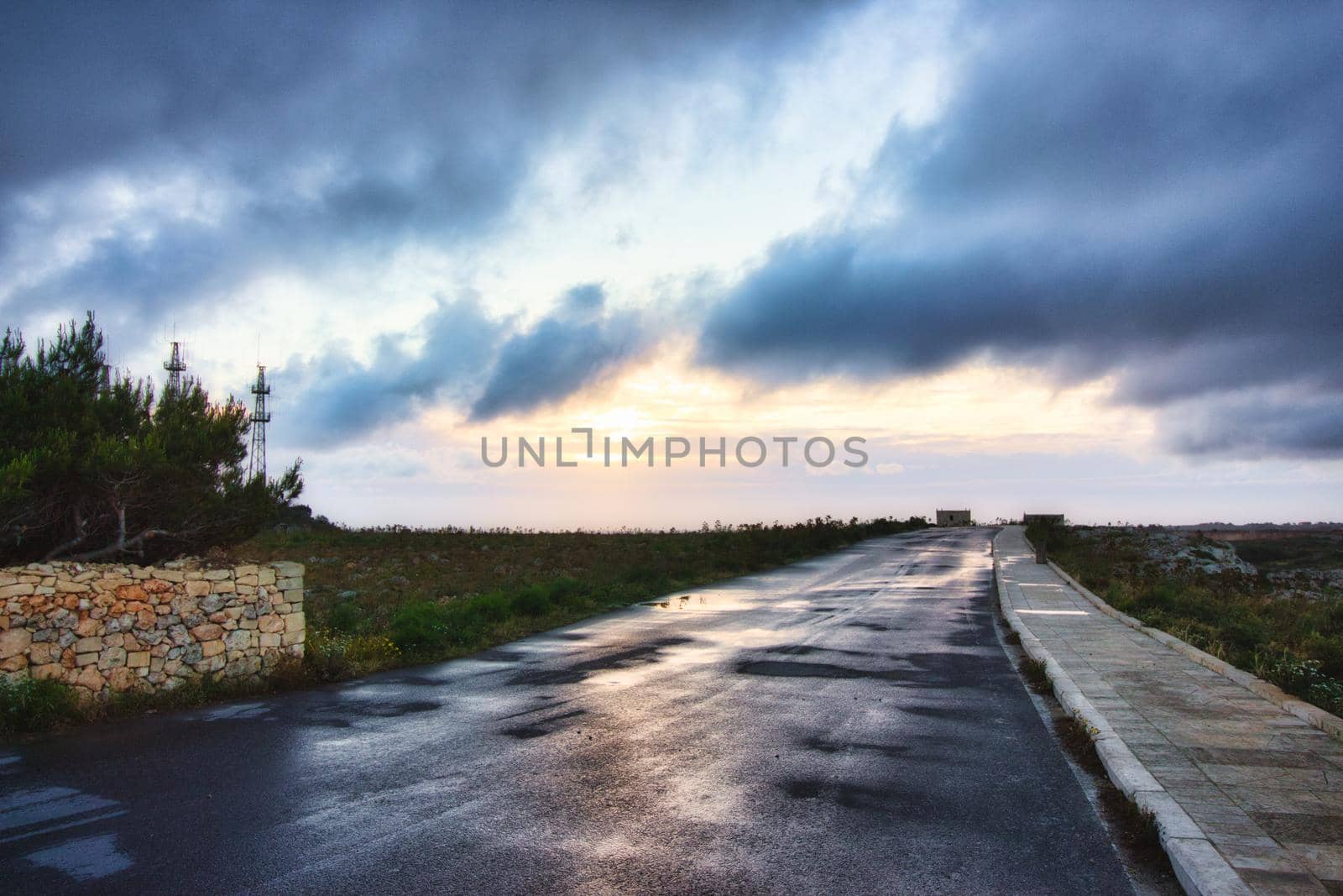 An empty road with a dramatic sky with moody clouds in the background by tennesseewitney