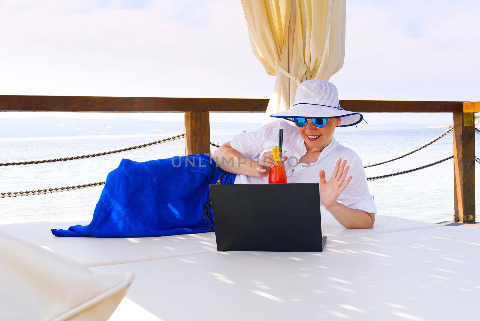businesswoman handle buisness on her trip by laptop at summer vacation. by PhotoTime