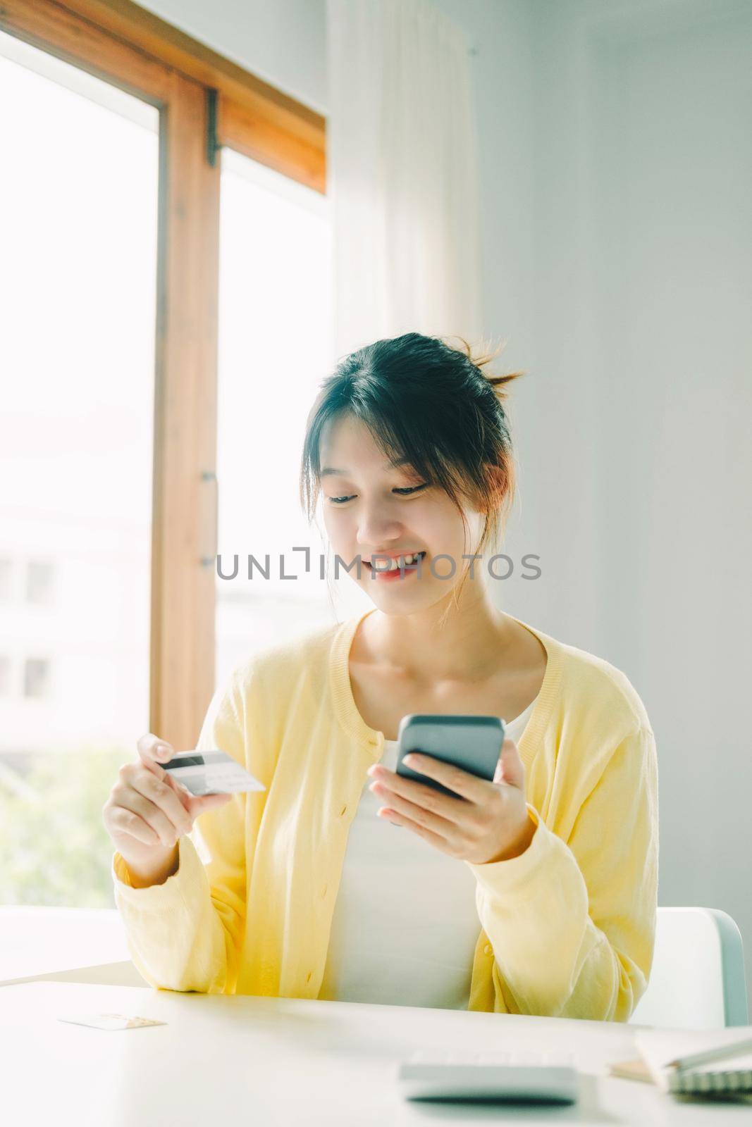 Close up woman using credit card for purchasing and shopping online on smartphone.
