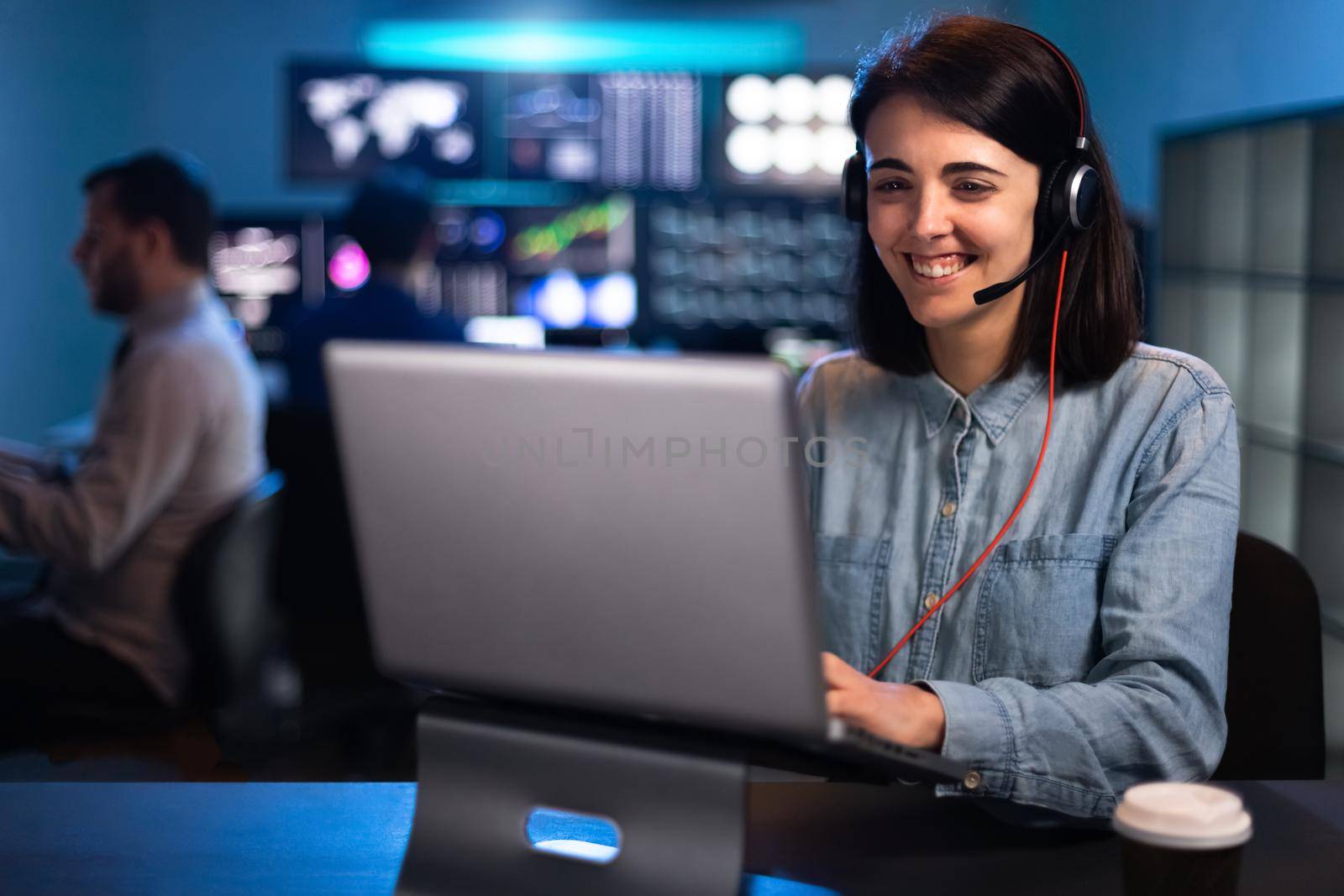 Happy young woman working with laptop in stock market trading analyst office. Costumer service call. Business concept.