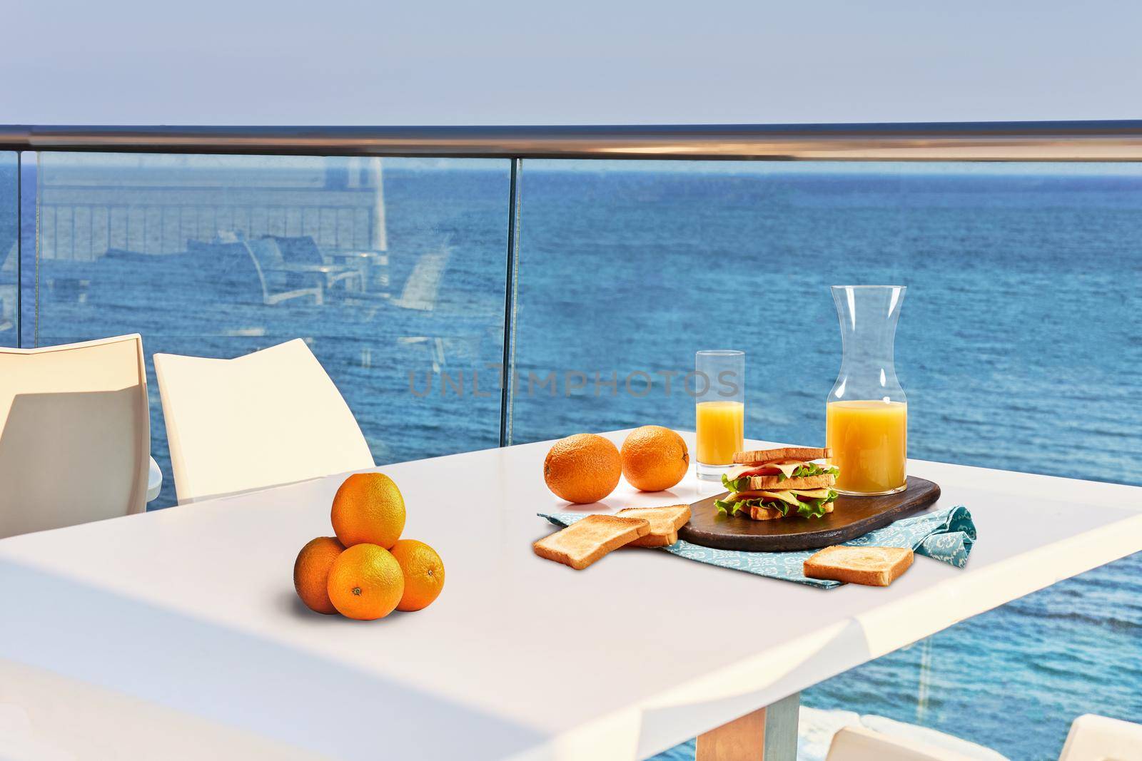 Table for two served with a breakfast on outdoor hotel balcony with a sea view. by nazarovsergey