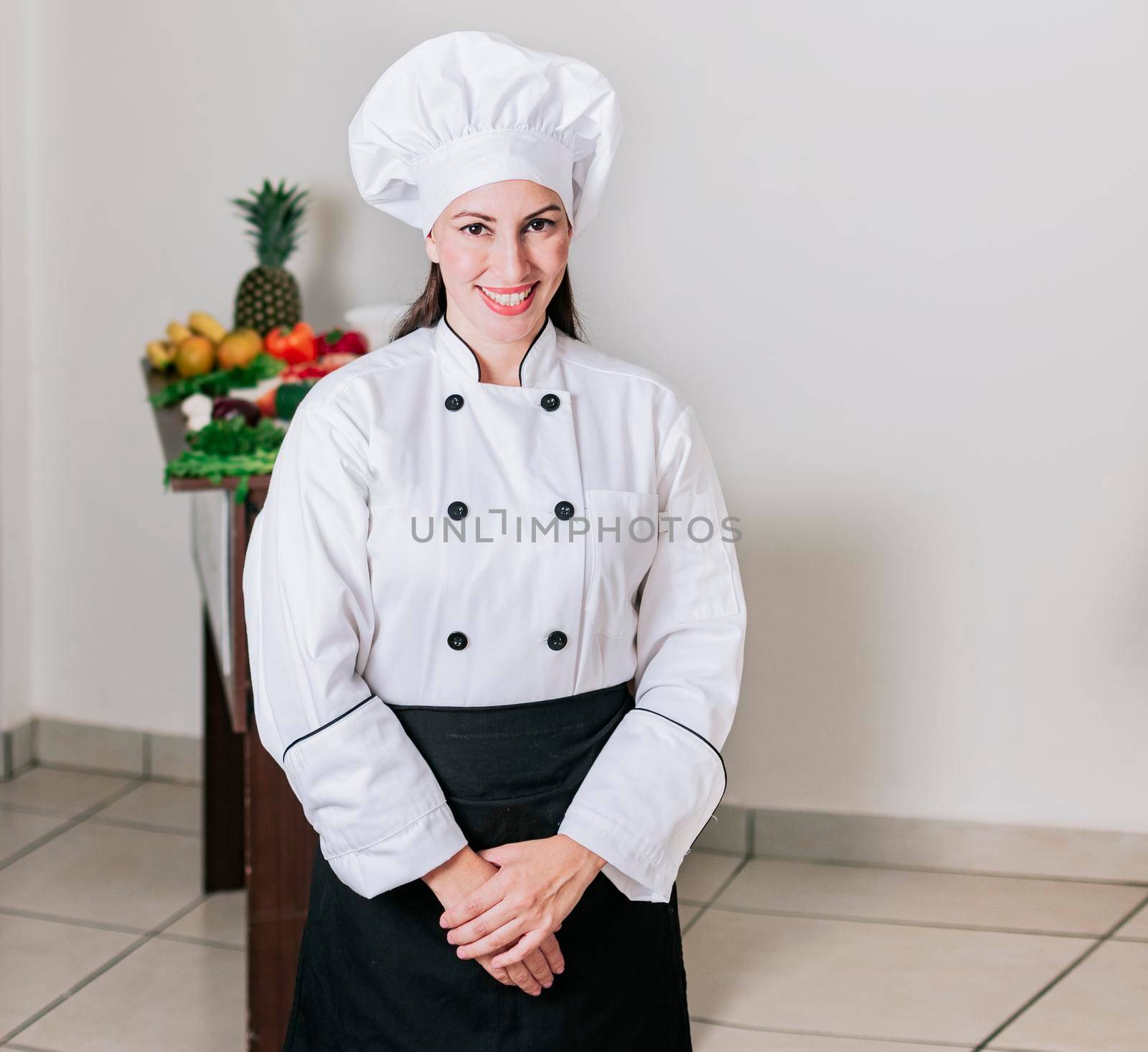 Portrait of a woman nutritionist in uniform with fresh vegetables on the table, A female nutritionist with a table of vegetables, Portrait of a female chef surrounded by fresh vegetables by isaiphoto