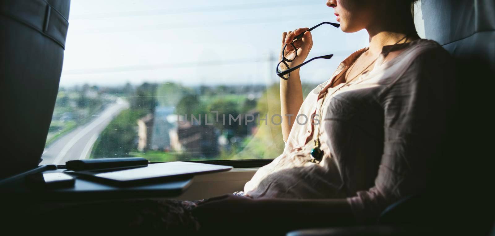 Woman traveling by train at window by SimmiSimons