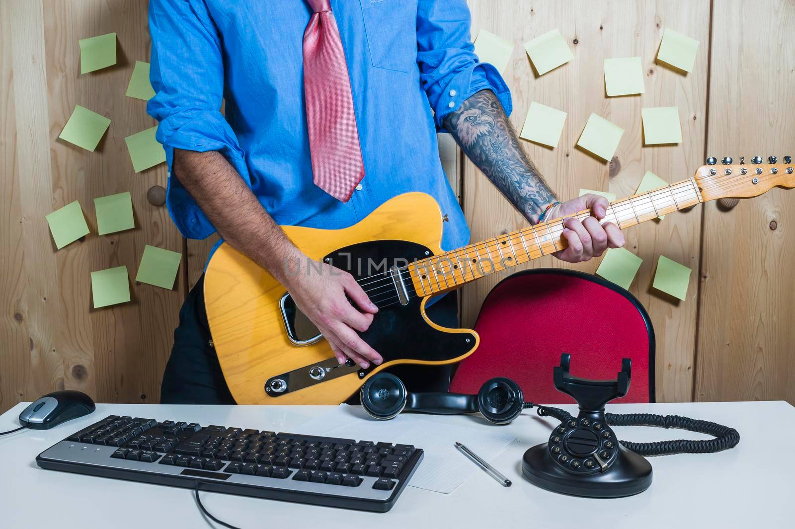Man playing a guitar in his home office.
