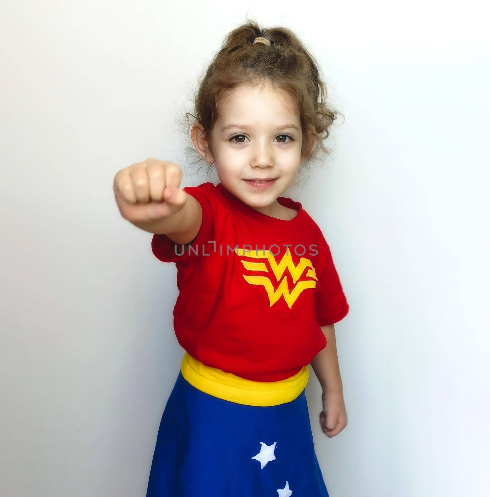 Portrait of a young cute girl posing as a super hero with Wonder Woman costume by tennesseewitney