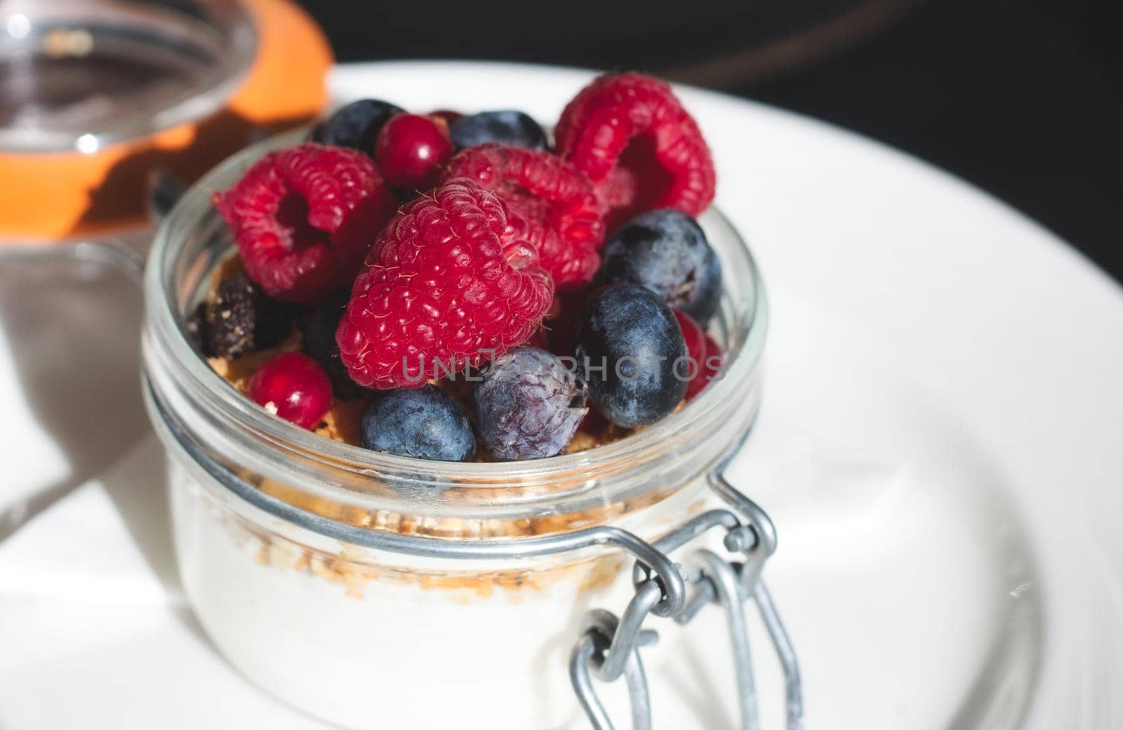 Homemade plain yogurt with granola and fresh fruit in a glass jar by tennesseewitney