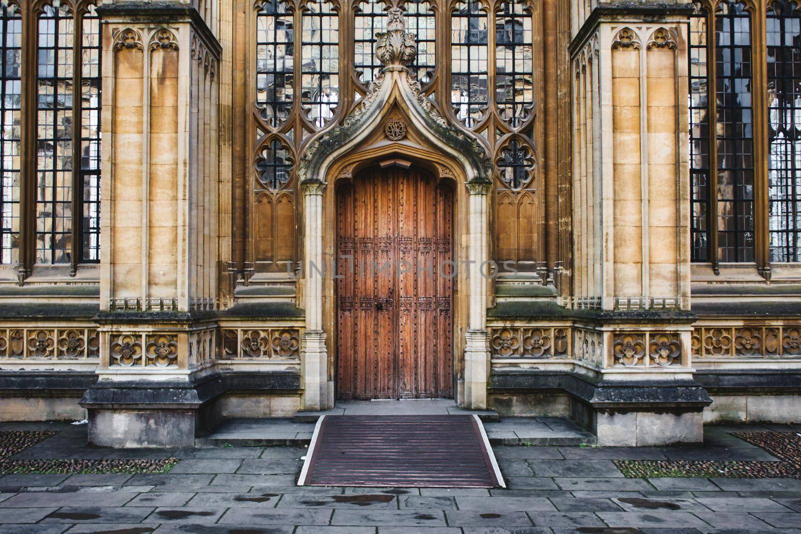 Oxford, UK - March 02 2020: Exterior of the Divinity School in Oxford showing a big wooden door entrance and columns and stained glass windows