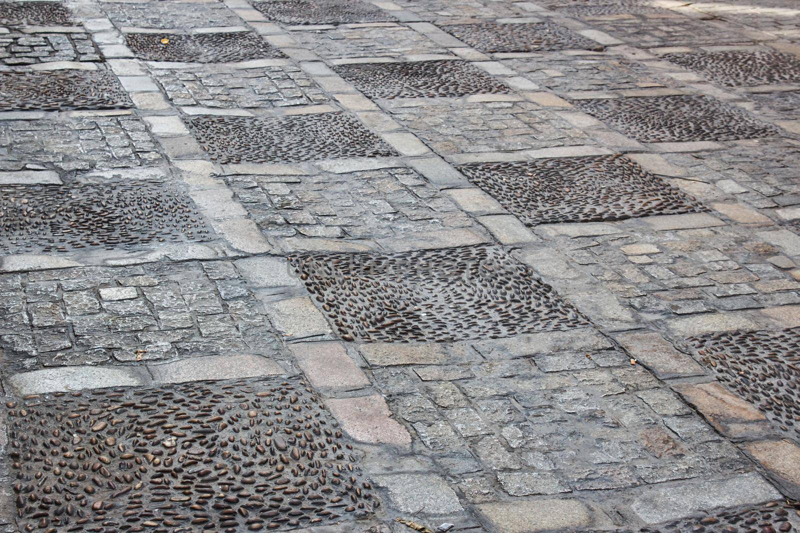 Cobblestone and tile texture on a street pavement sidewalk by tennesseewitney