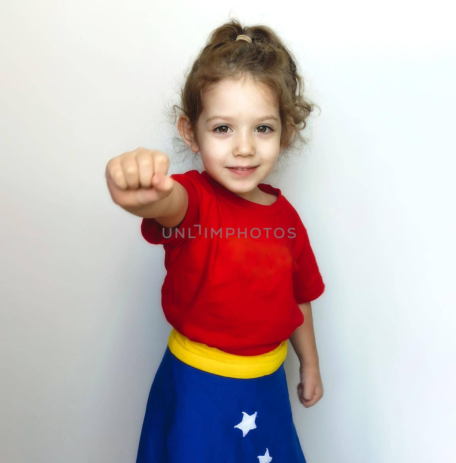 Portrait of a young cute girl posing as a super hero with Wonder Woman costume by tennesseewitney