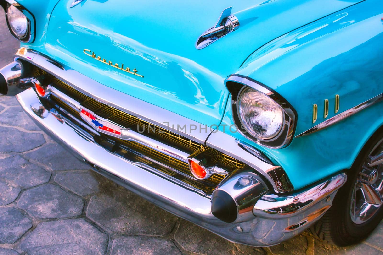 Closeup of the front of an aqua marine blue 1957 Chevrolet 150 with bullet bumper guards by tennesseewitney