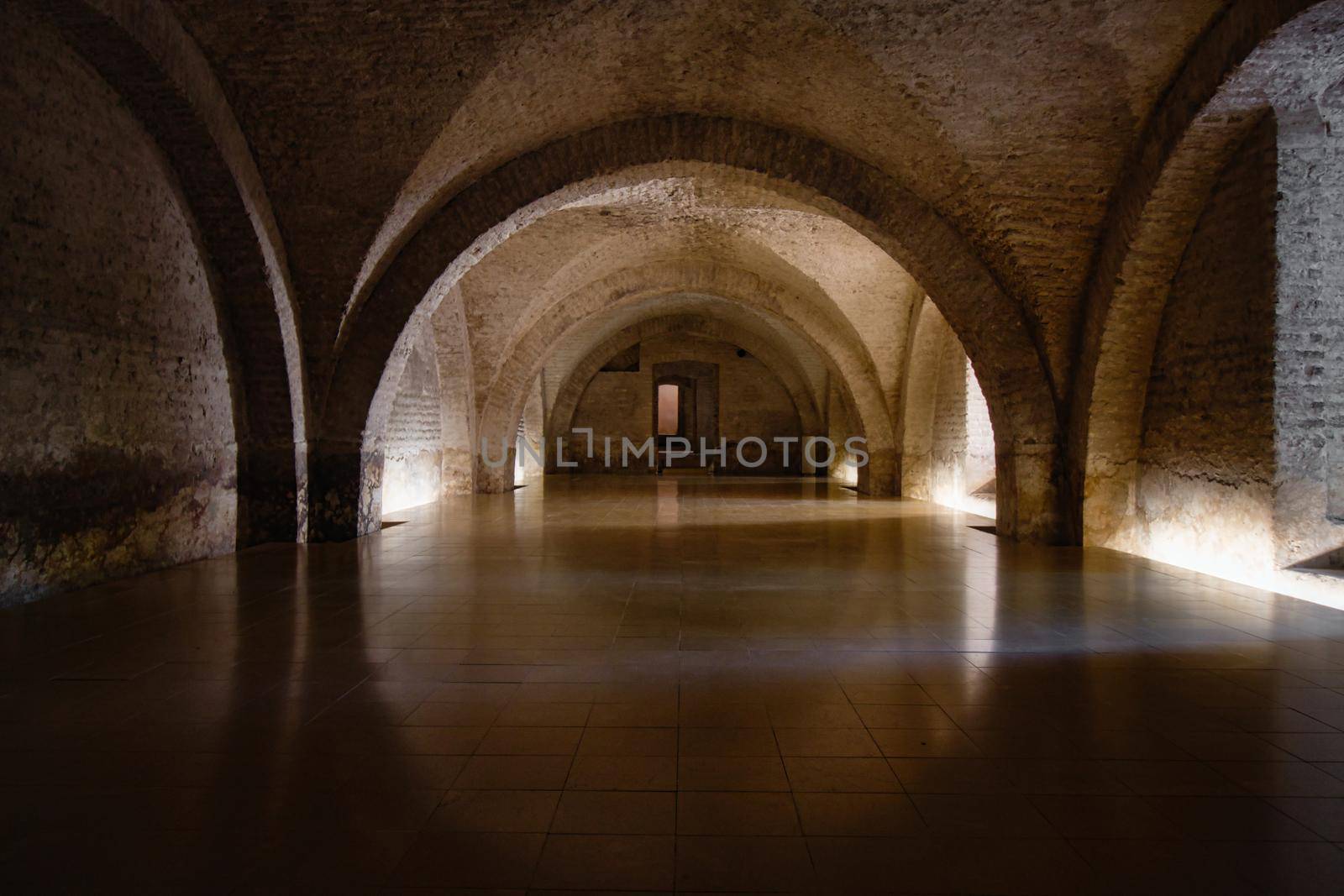 Empty cellar with electric light and old historic arches